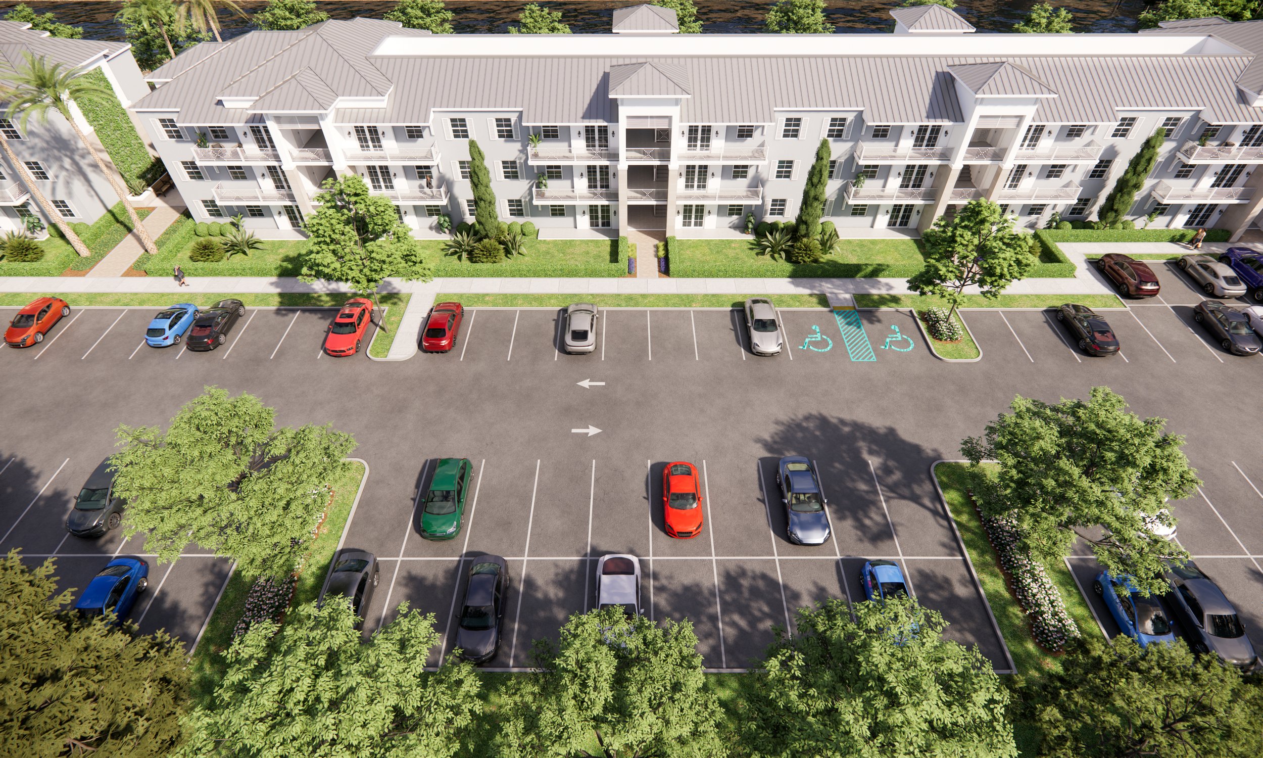Aerial view of a residential apartment complex with parking lot, trees, and landscaped areas.