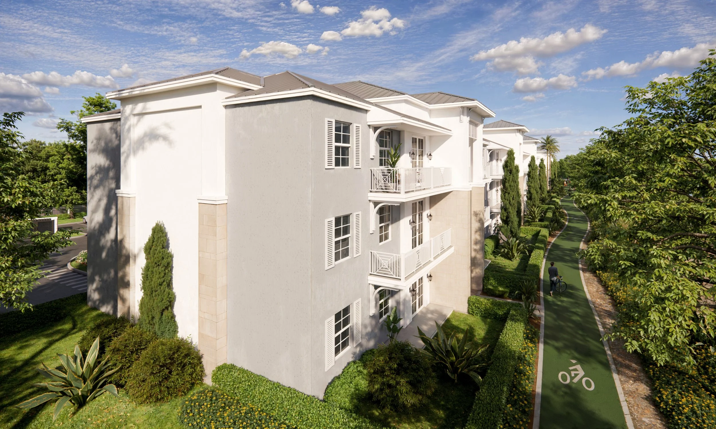 A three-story white residential building with balconies, surrounded by green trees, bushes, and a walking/biking path with a person biking.
