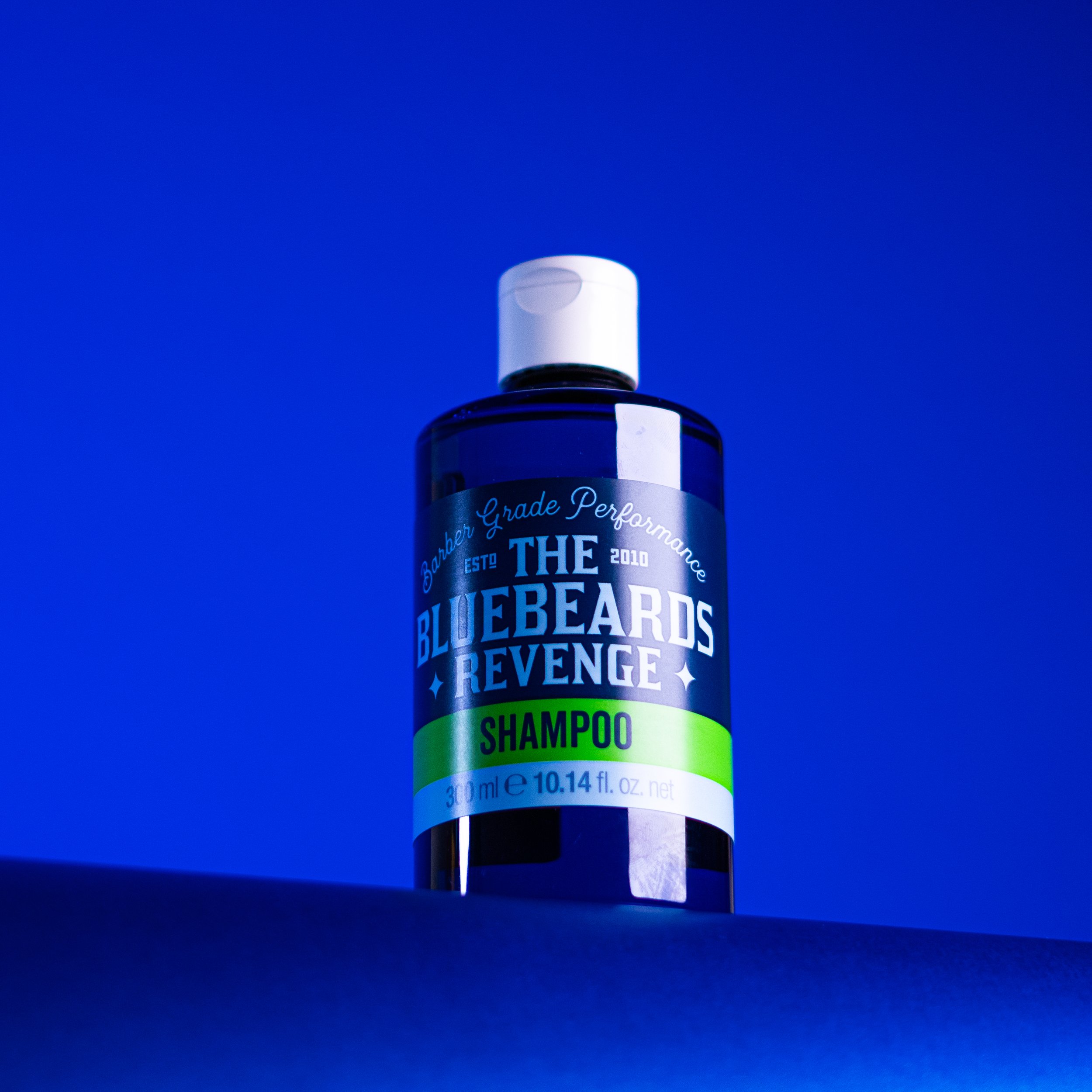 A blue shampoo bottle labeled 'The Bluebeards Revenge Shampoo' against a blue background.