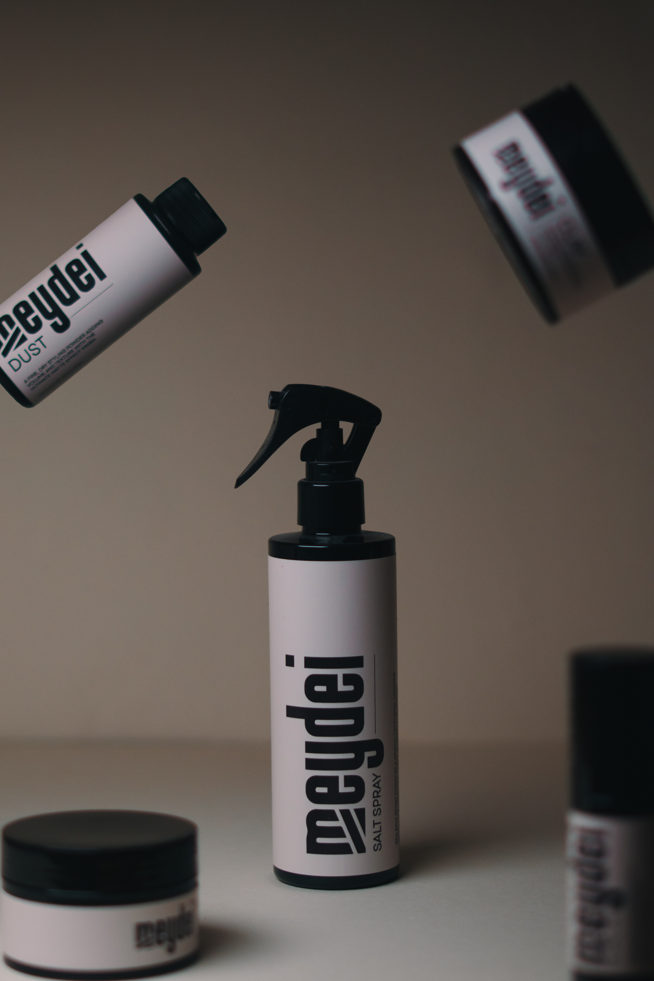 Various containers of aromatic salt spray, including a spray bottle with a trigger, a small jar, and other containers on a neutral background.