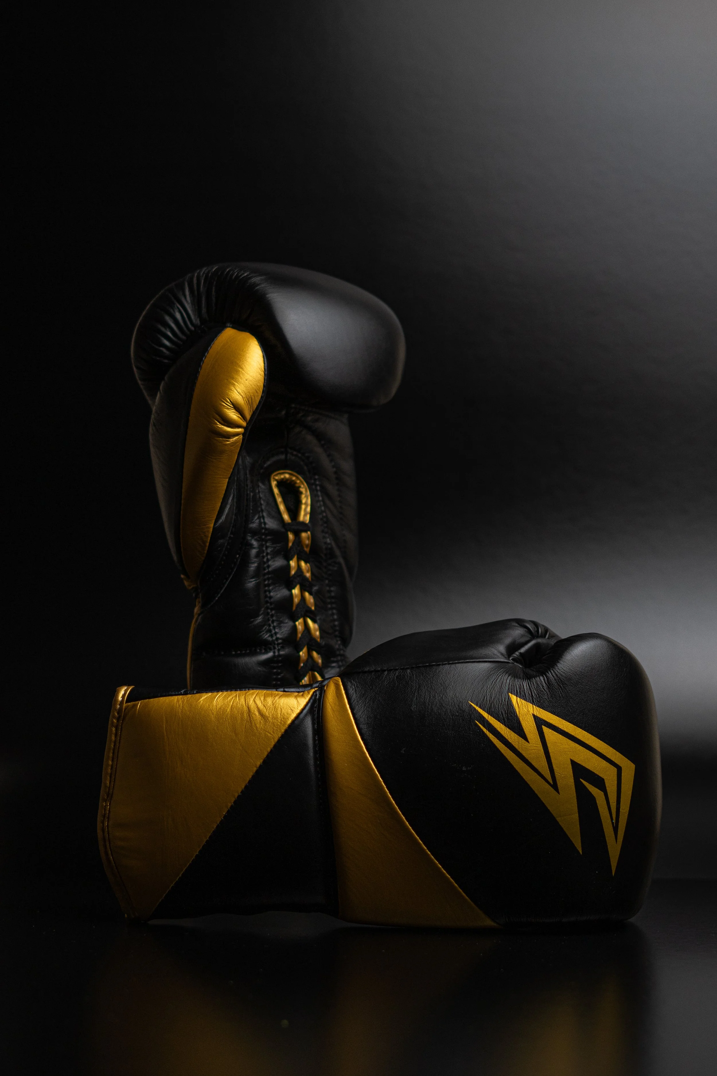 Black and gold boxing glove against a black background.
