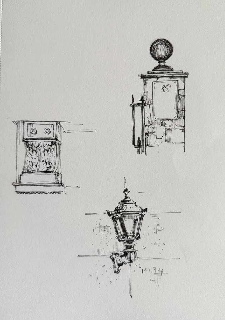 Sketch of three vintage street lamps and a decorative wall feature.