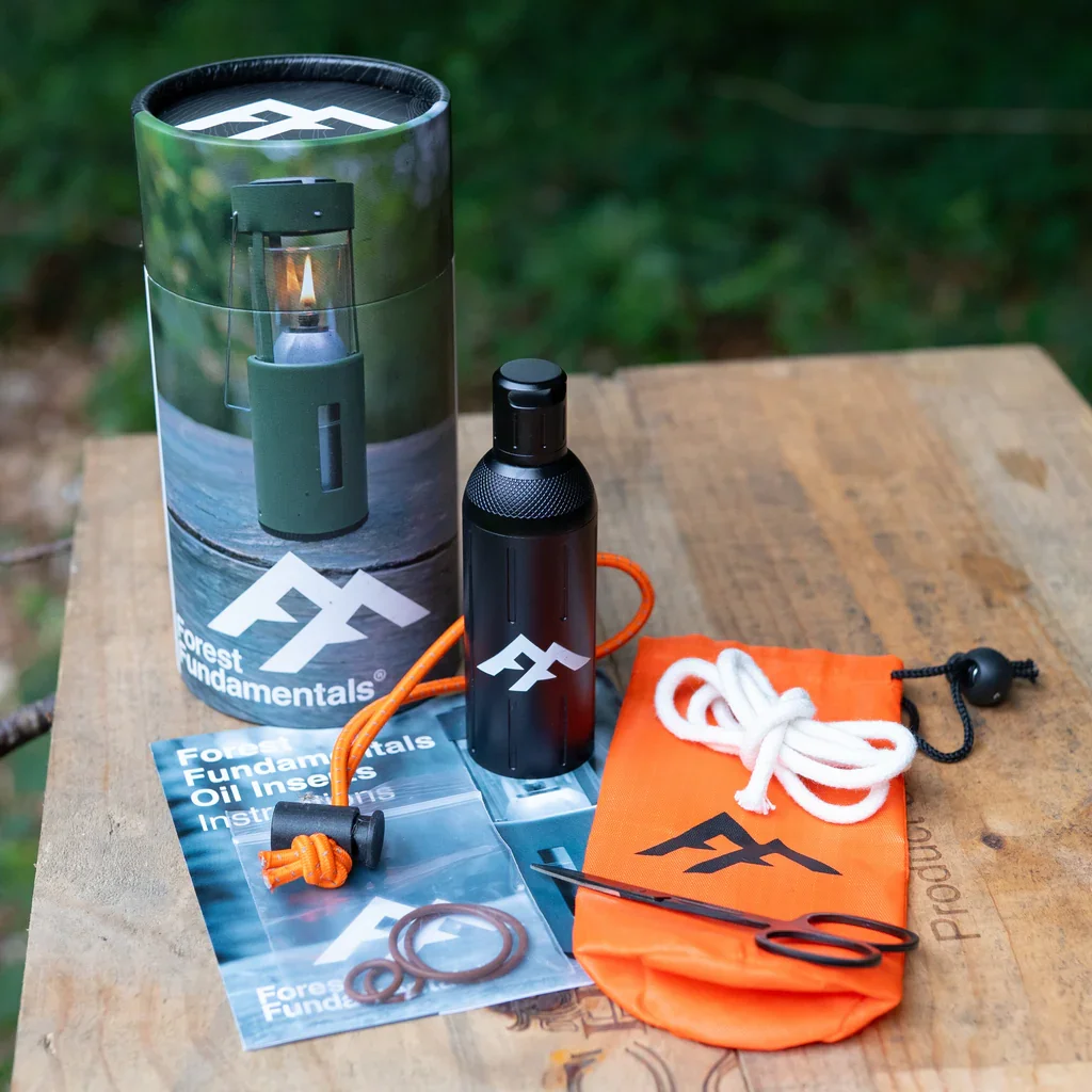 Forest Fundamentals oil insert for UCO lantern in outdoor woodland setting