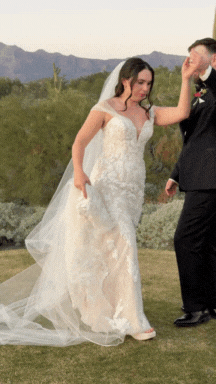 Bride and groom dancing outdoors with mountains in the background at their wedding.