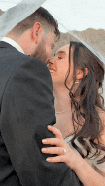 A bride and groom sharing a close moment, smiling at each other.