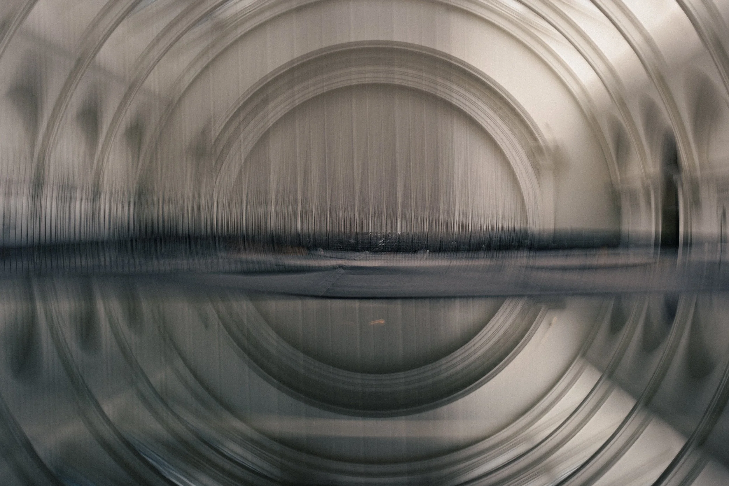 Motion frame of a room with a curved ceiling showing concentric rings and lines, creating a blurred, abstract pattern.
