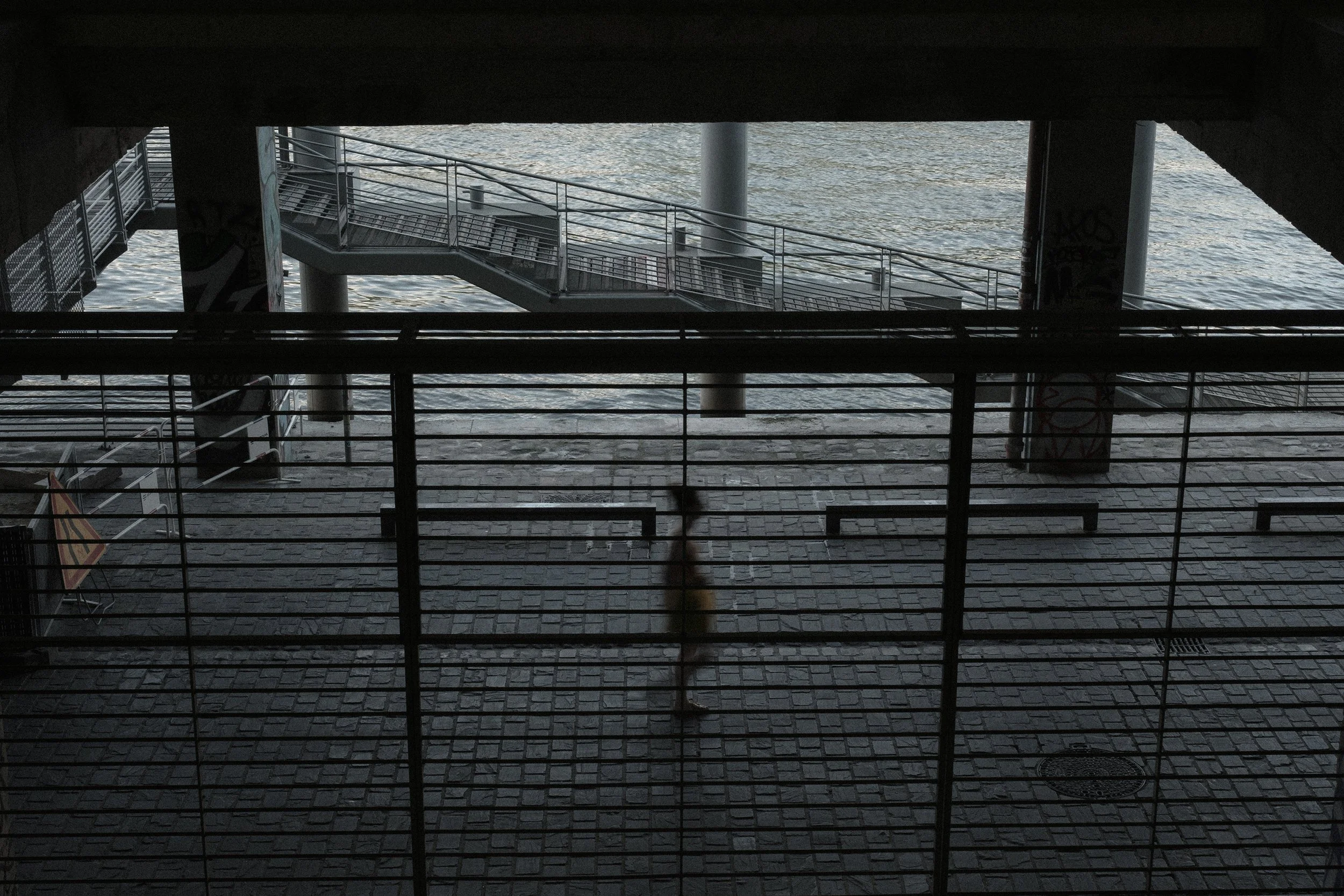 Underpass view overlooking water with stairs and railings