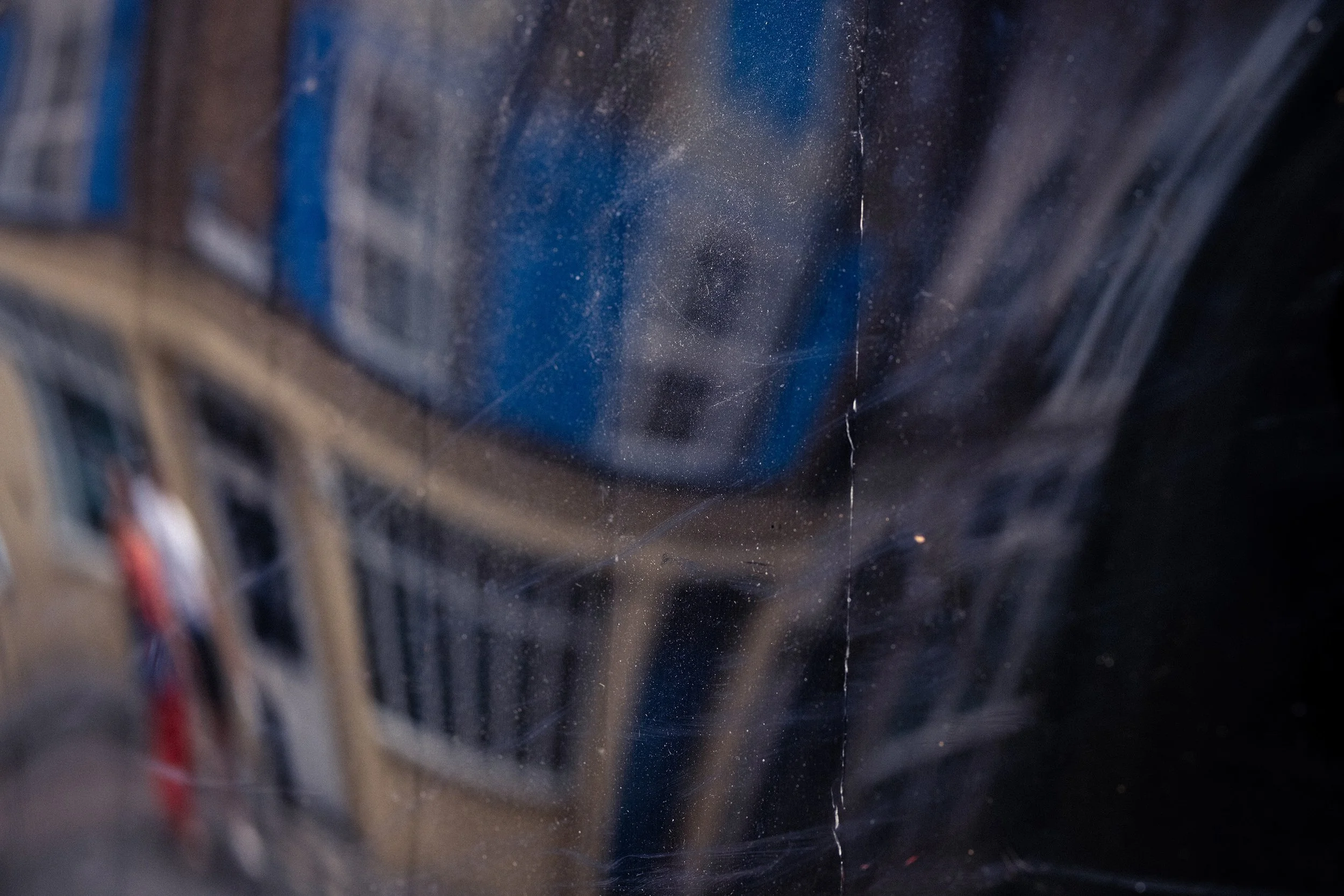 Warped reflection of a house with a couple walking in front of it. 