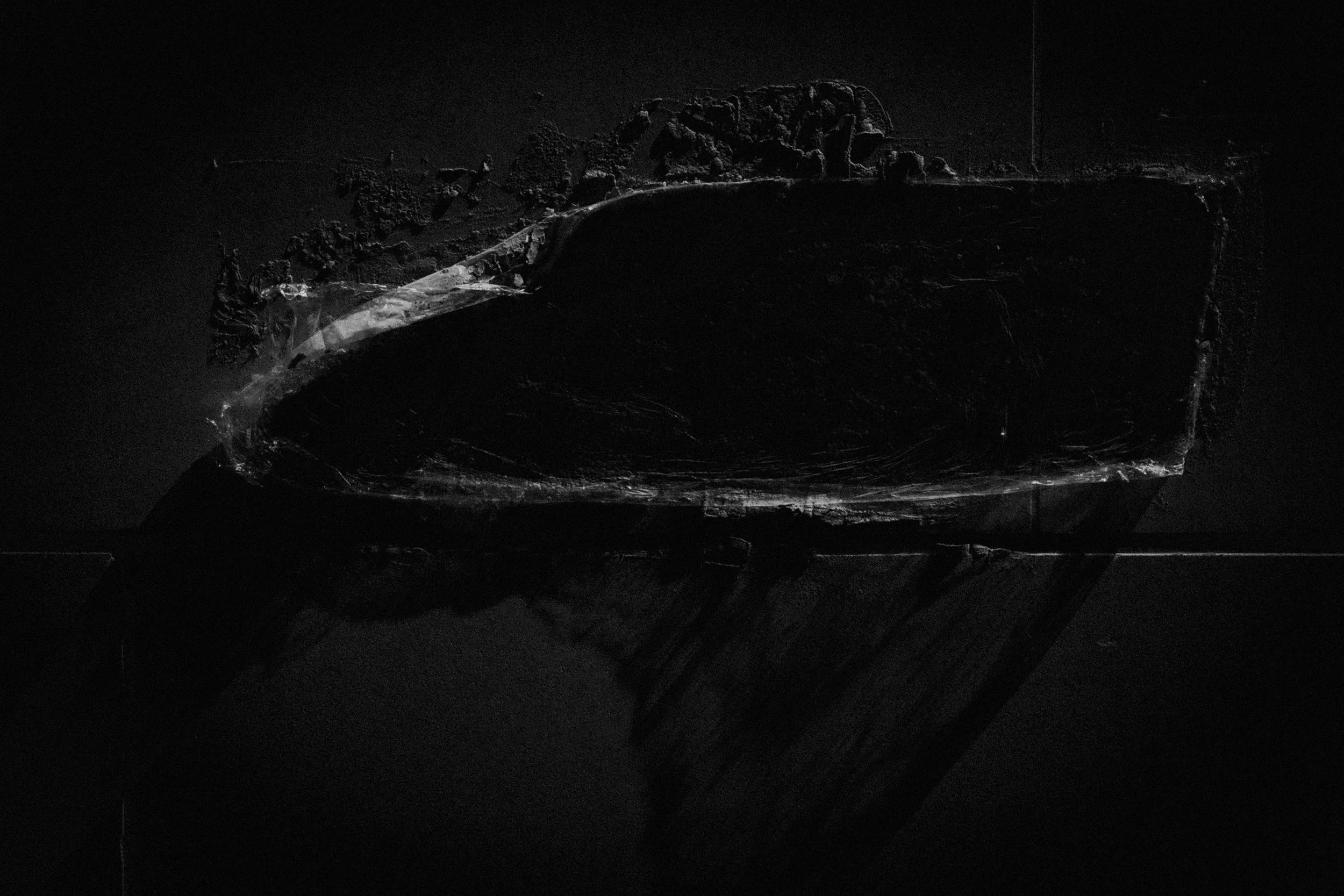 High contrast black-and-white image of plastic foil plastered to stone wall. 