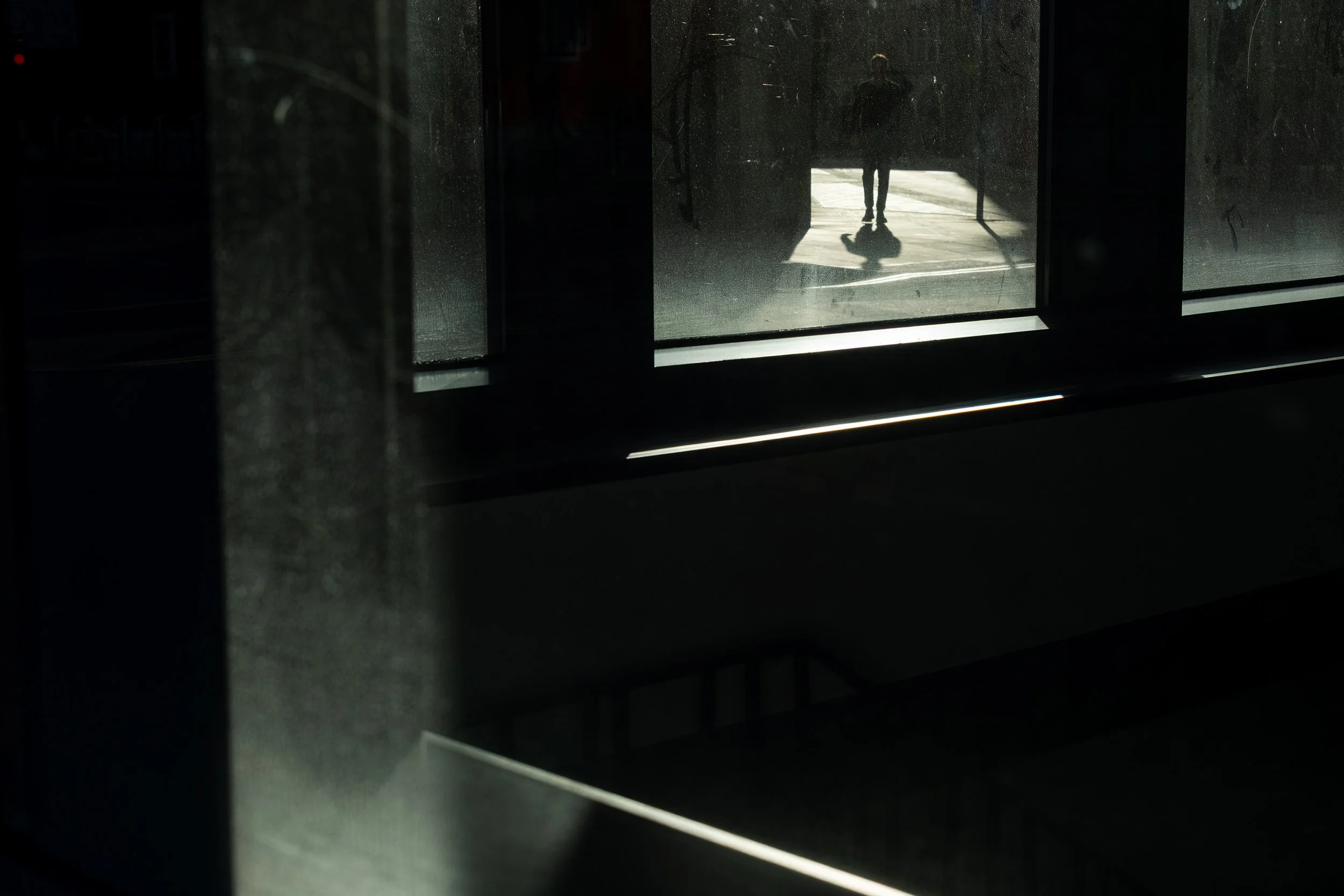 A small silhouette of a person walking down an alley.