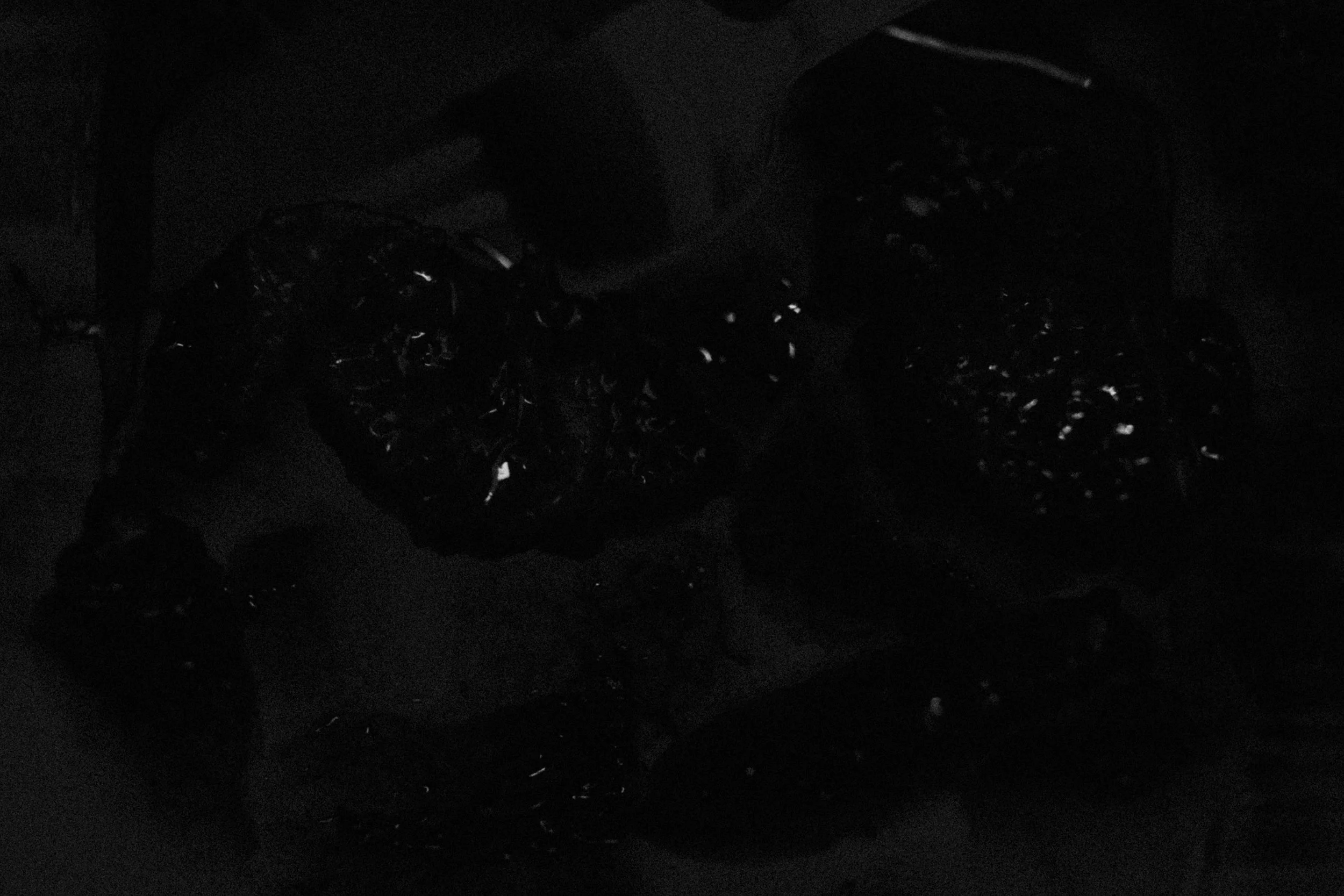 Dark abstract shot of a close-up of a container with fresh mandarins and a fork. 