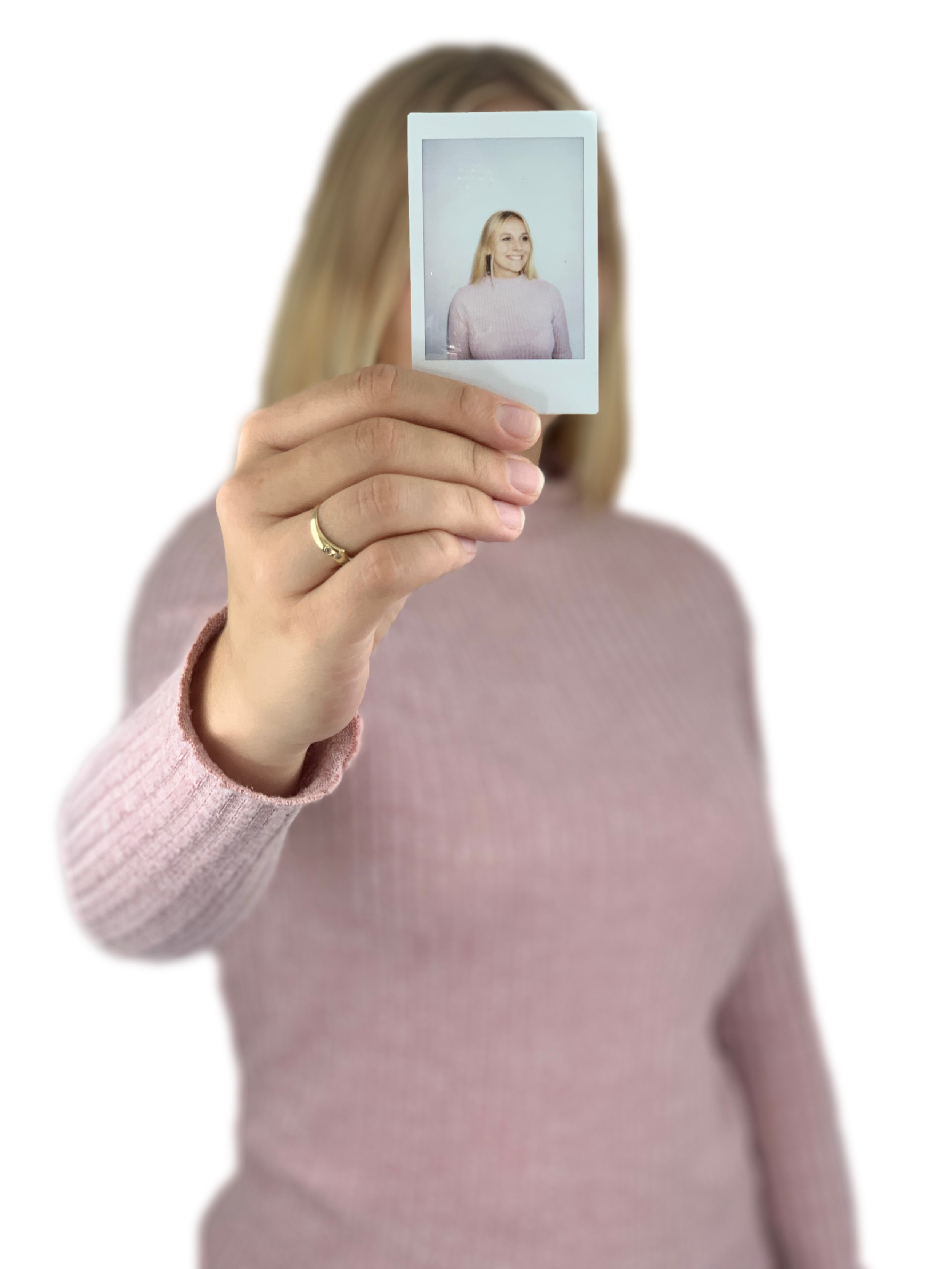 Frau hält ein Foto in der Hand, auf dem sie selbst zu sehen ist, mit blondem Haar und rosa Pullover.