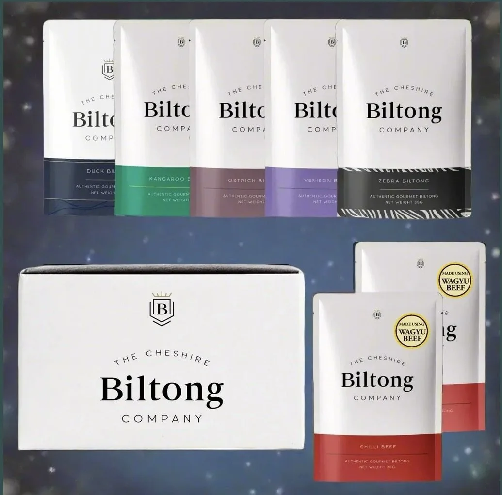 Display of various flavored Biltong packages from The Cheshire Biltong Company, including duck, kangaroo, ostrich, venison, zebra, and beef flavors, with some showing labels indicating Wagyu beef.