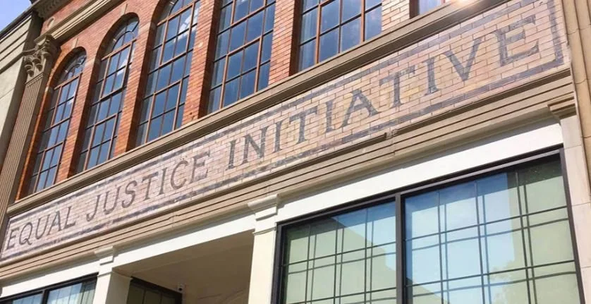Close-up of a building with a sign that reads 'Equal Justice Initiative' on the facade.