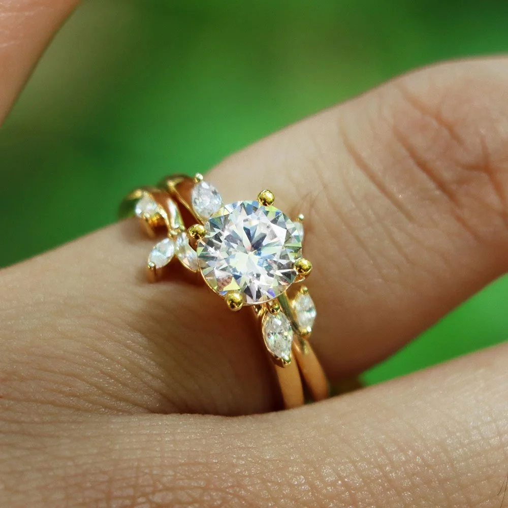 Close-up of a gold ring with a large central diamond and smaller diamonds on a person's finger.