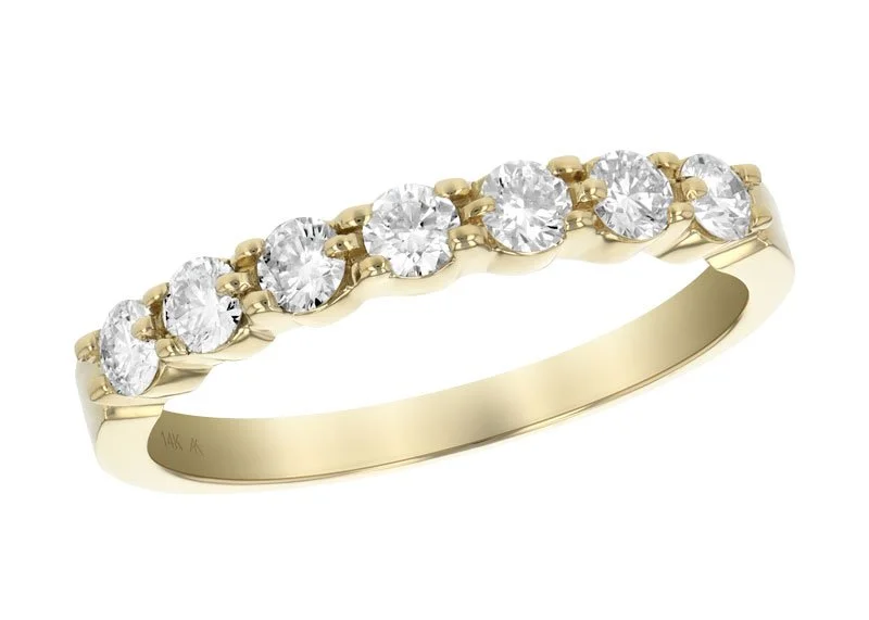 A gold wedding ring with seven round-cut diamonds set in a row.