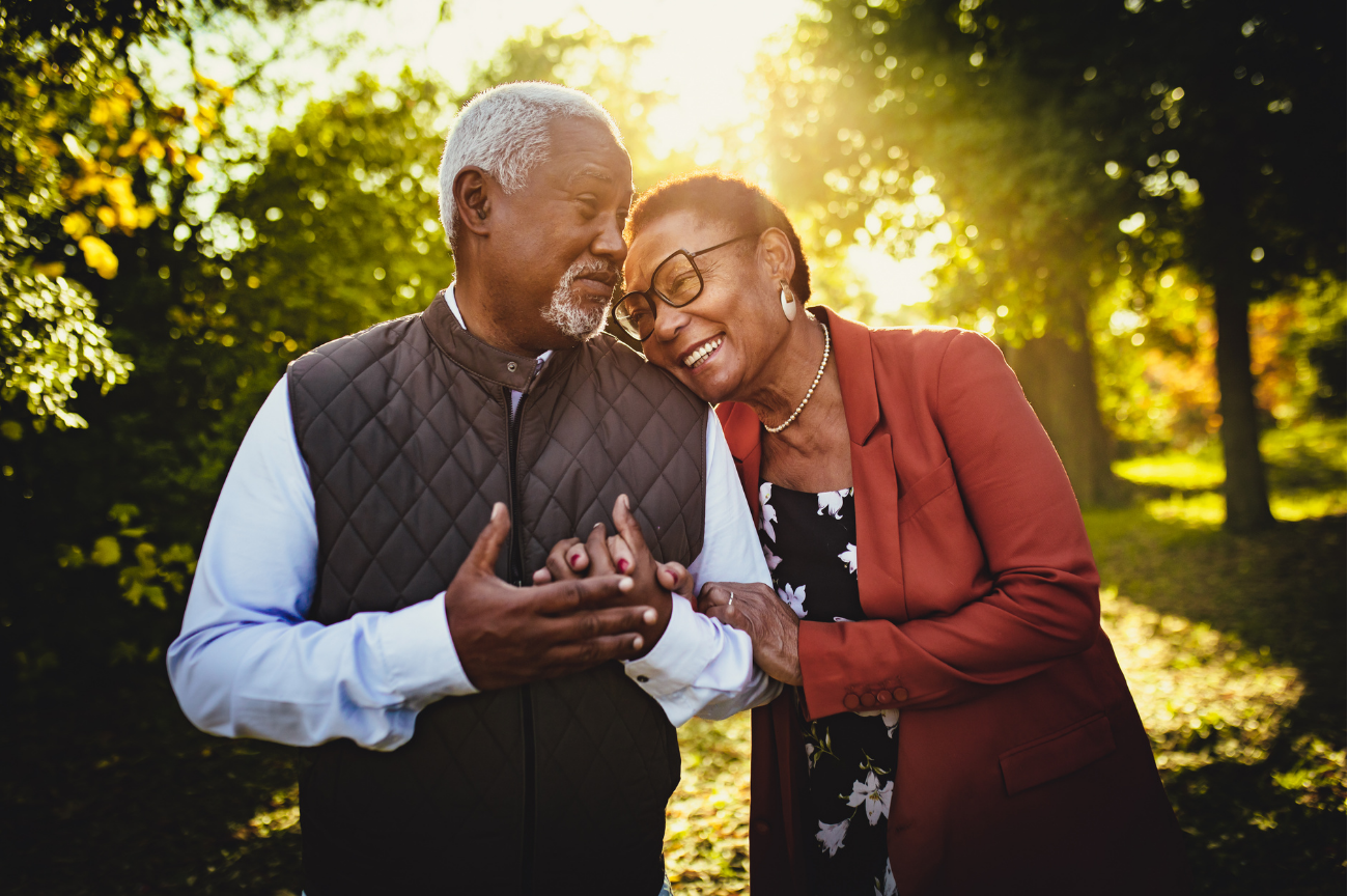 Older couple spending time together outdoors at sunset.