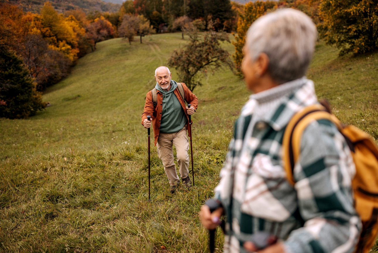 Older adults hiking together in an autumn landscape.