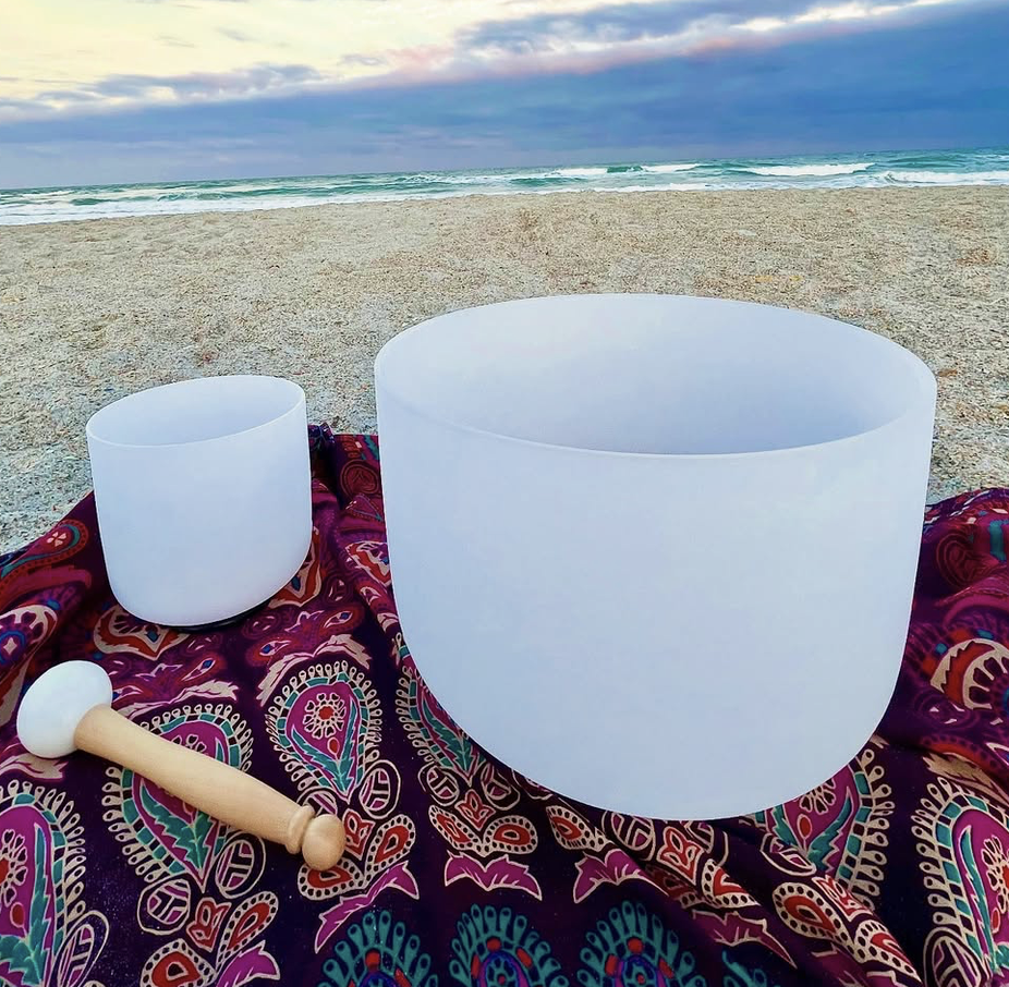 two sound bowls on the beach with a blue sky