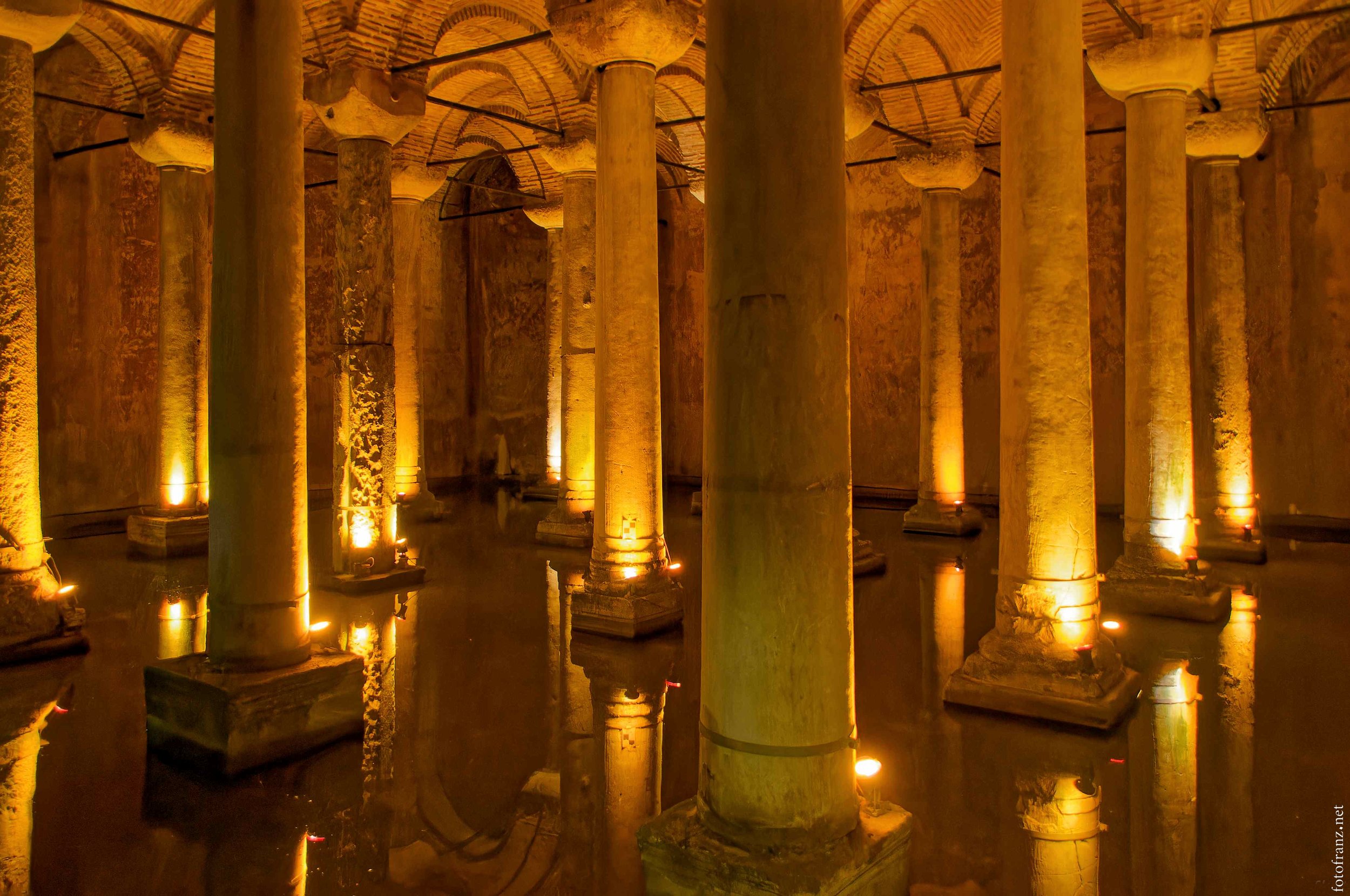 Alte römische Therme mit Säulen und Wasserbeleuchtung in warmen Tönen
