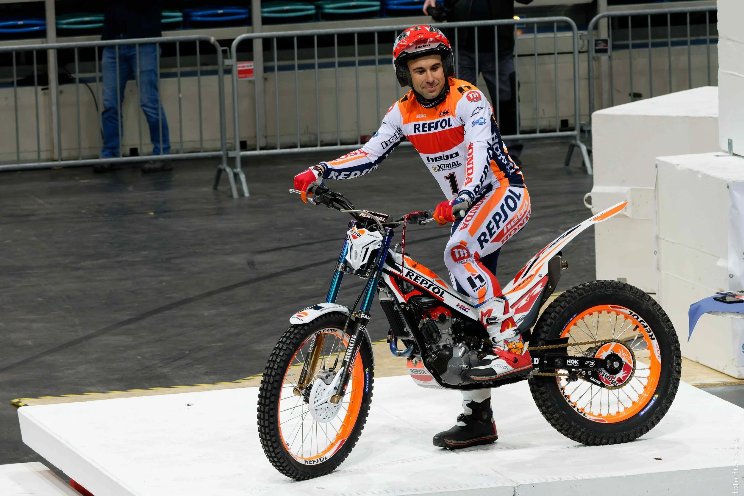 Motorradrennfahrer in Repsol Honda Team-Outfit auf Siegerpodest mit Bike bei einem Rennen