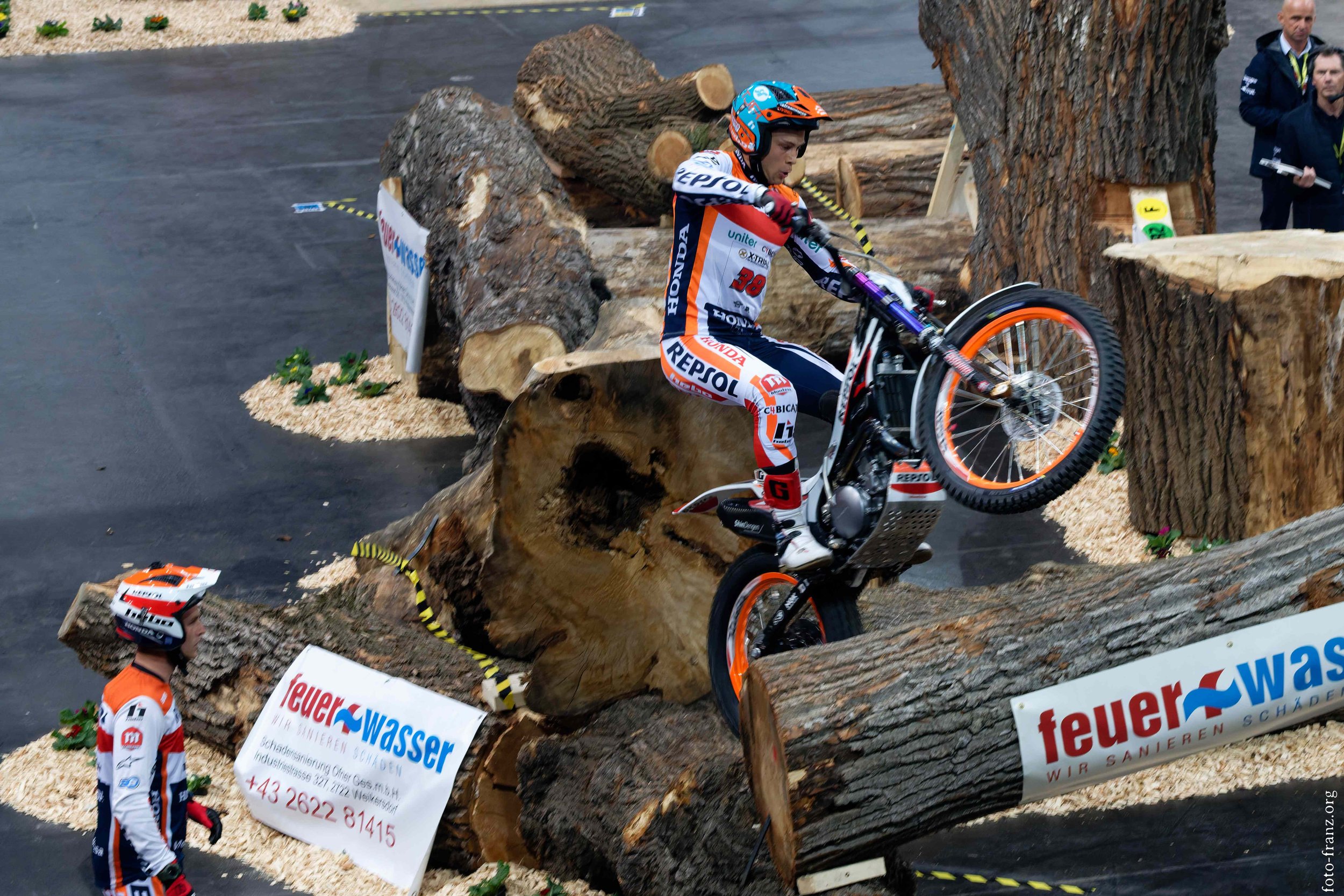 Motorradfahrer beim Trials auf Baumstamm