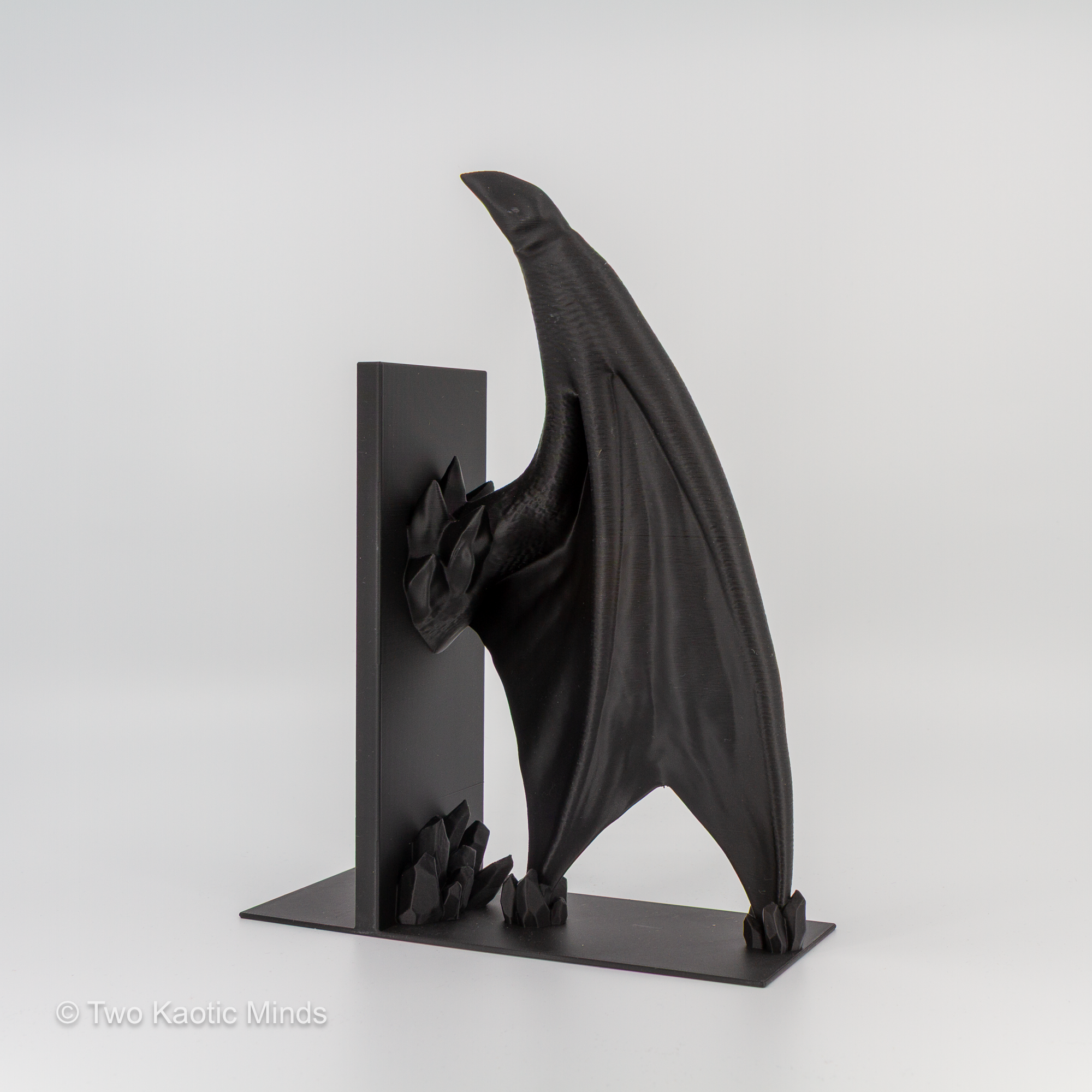 Single matte black Frost Dragon wing bookend showing full wing span and base detail, side angle view