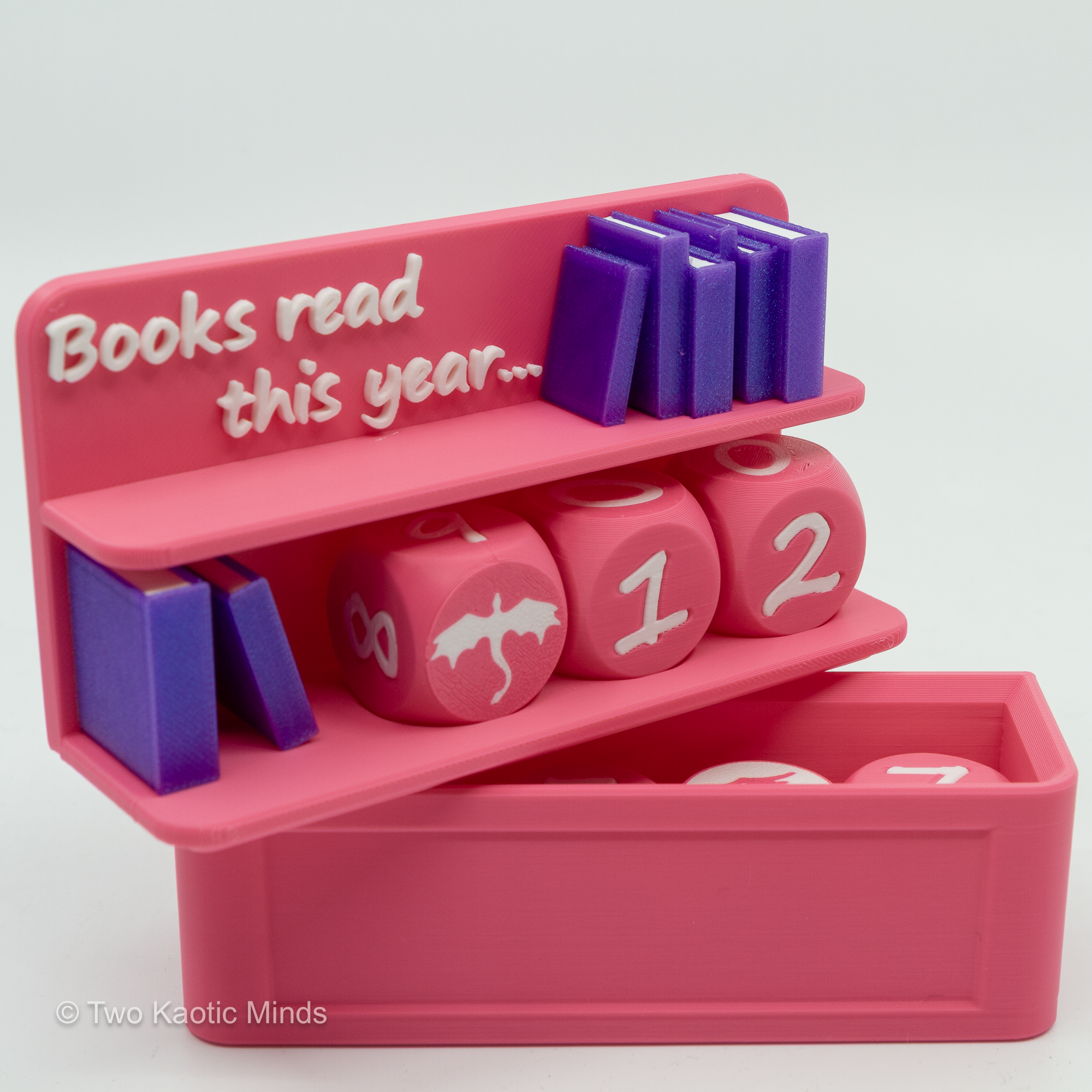 Pink Book Counter shelf decor with lid off and dice stored inside tray, top-down angle