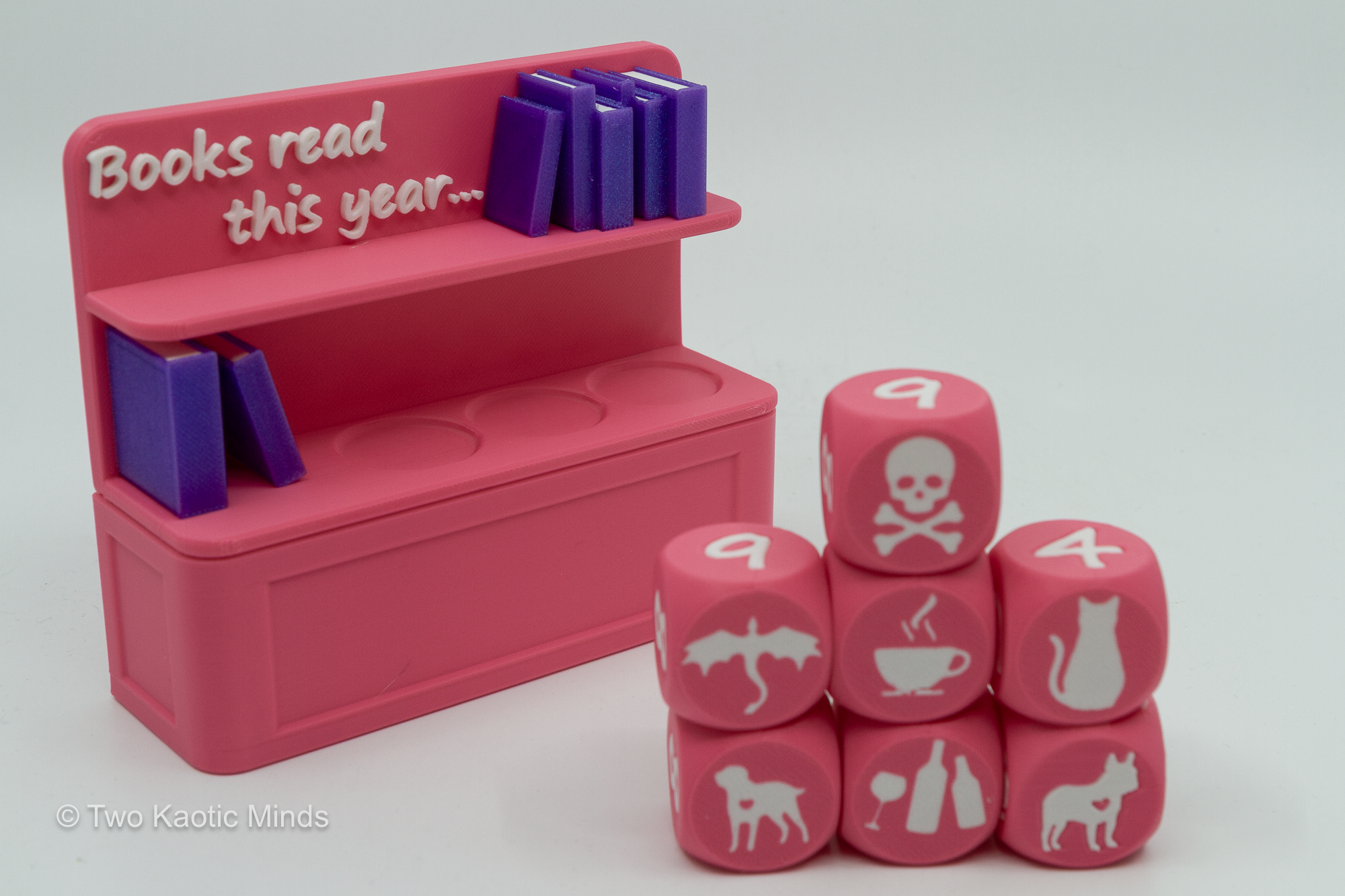 Close-up of six custom icon dice showing skull, coffee cup, cat, dog, and other icon faces