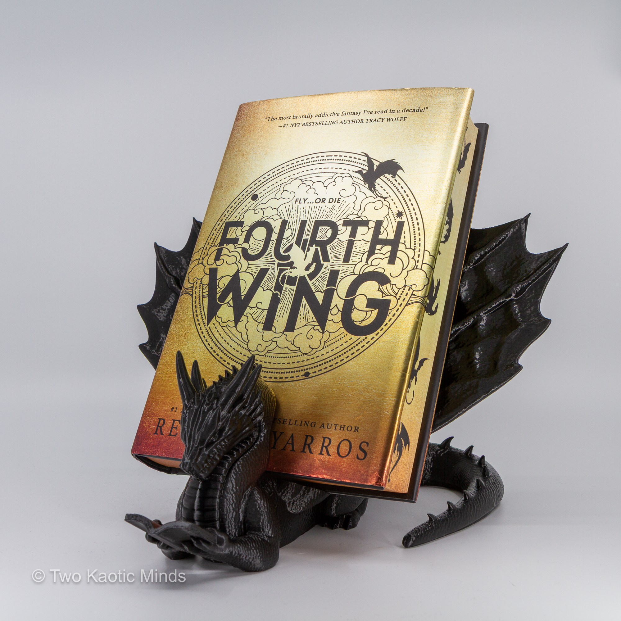 Black dragon book holder in use with a copy of Fourth Wing standing upright in the slot between the dragon's body and tail
