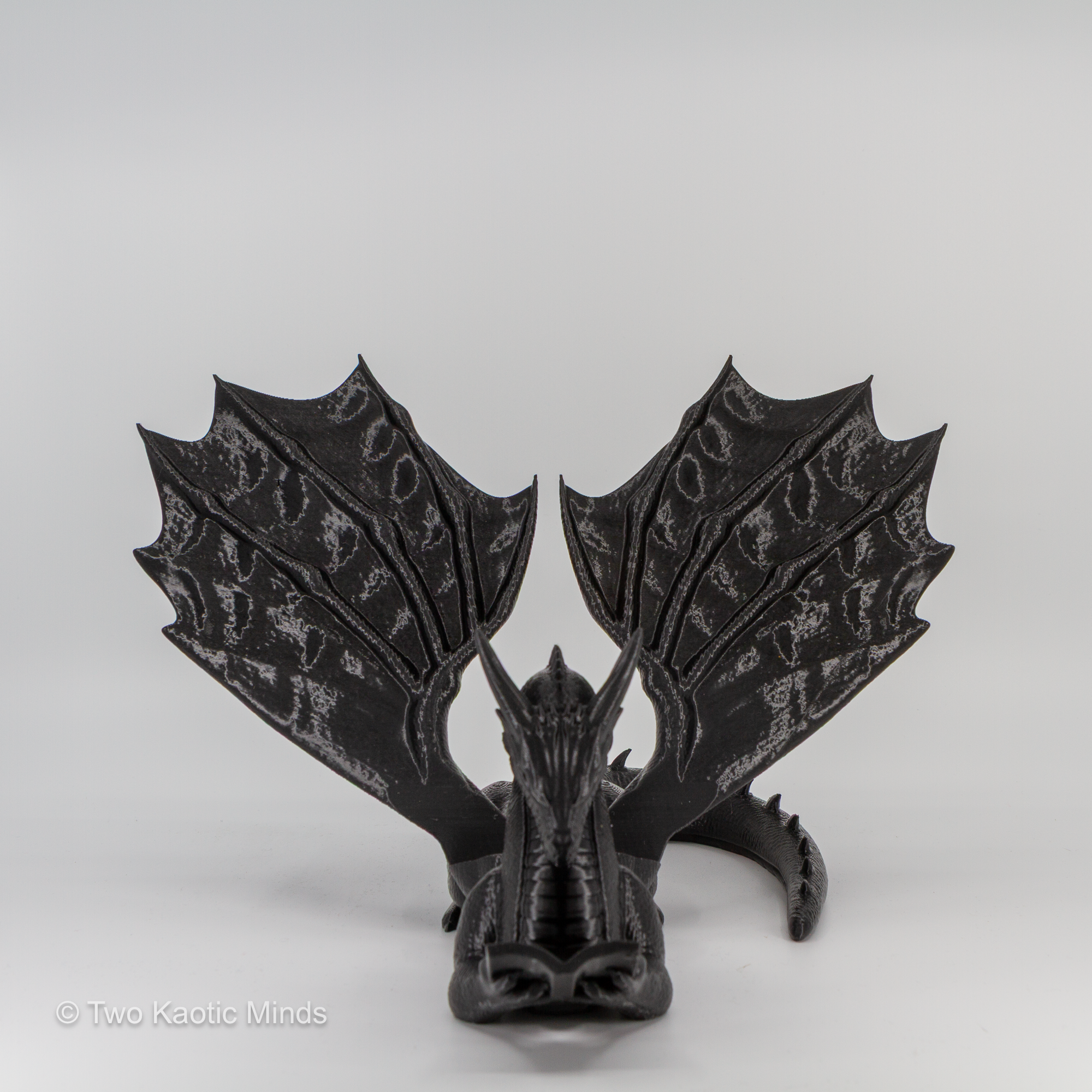 Black dragon book holder side angle view showing wing detail and tail slot on grey background