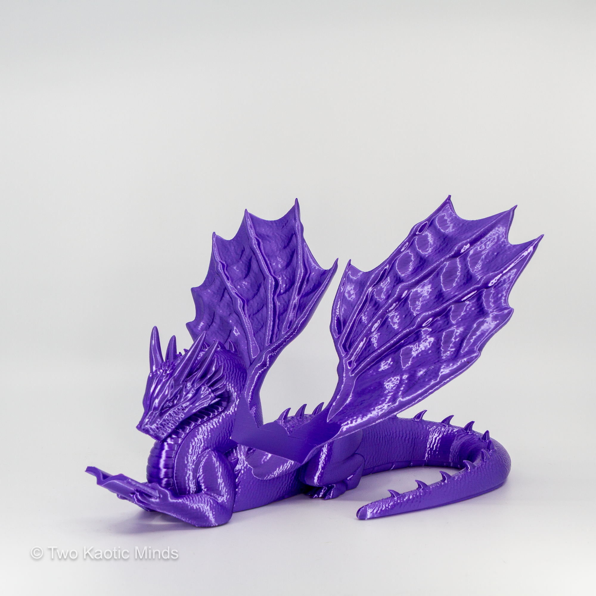 Rear angle view of purple 3D printed dragon book holder showing full wing span and tail