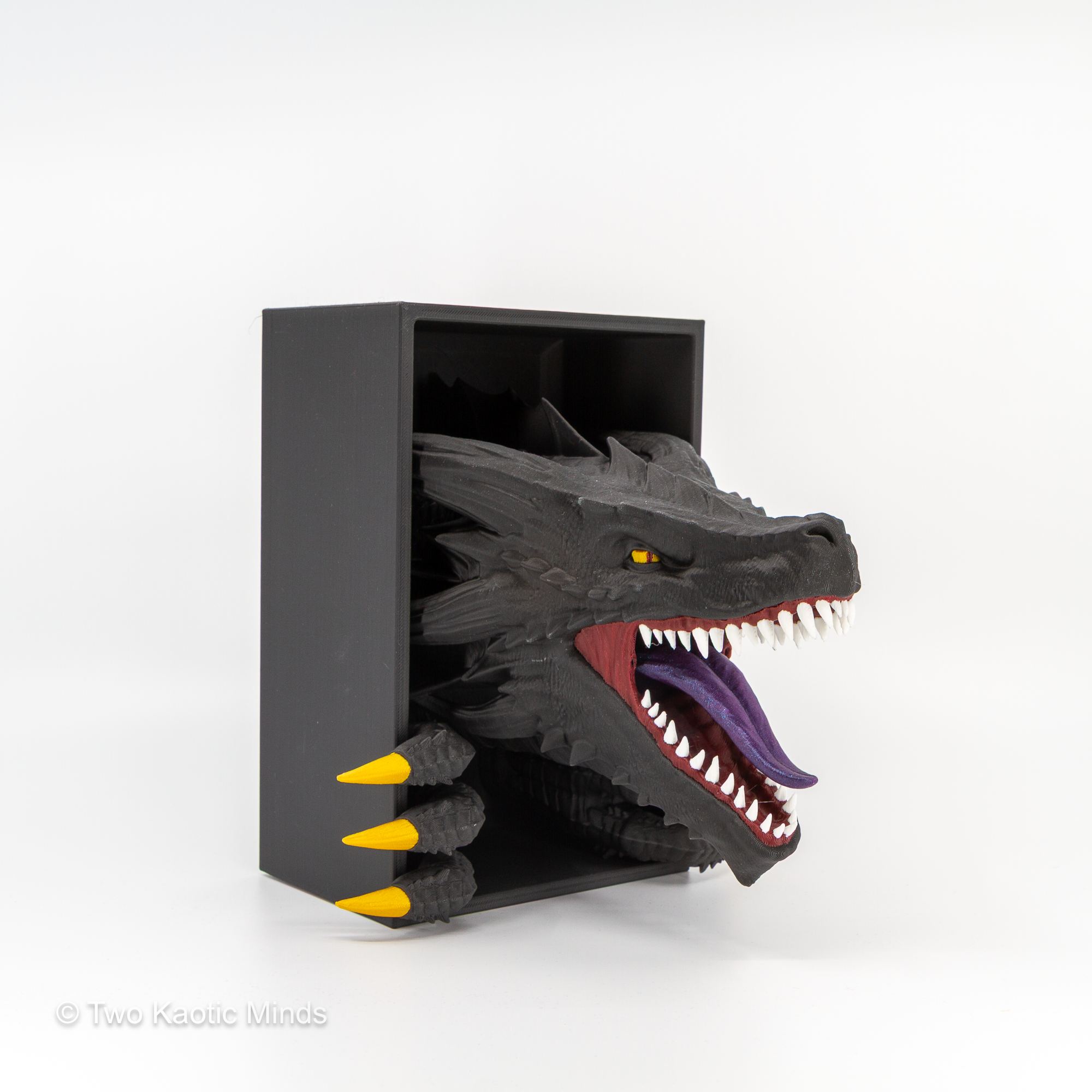 Angled front view of the Emerging Dragon book nook showing wide open jaws with purple interior, gold teeth, and matte black dragon head with gold spines
