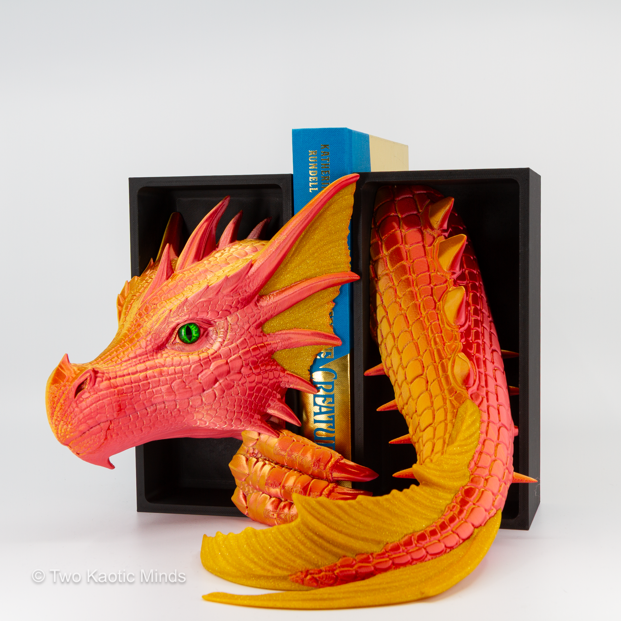 Close angle of the Sunset-Gold Sea Dragon showing opaque gold fin and scale accents and green glass eye against warm red-orange body