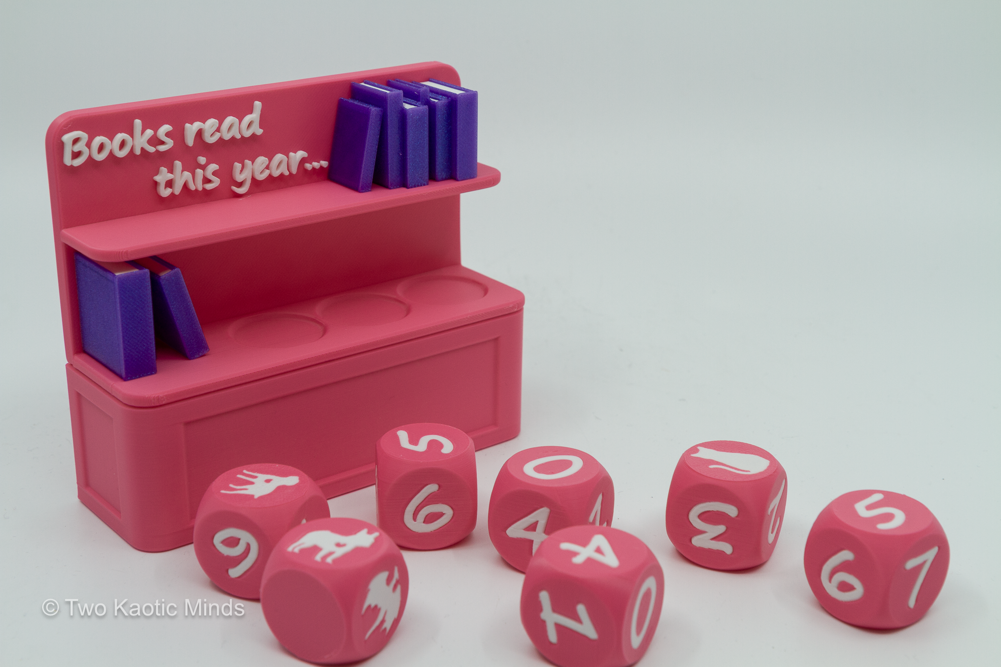 Pink Book Counter with all six dice spread out in front showing various number and icon faces