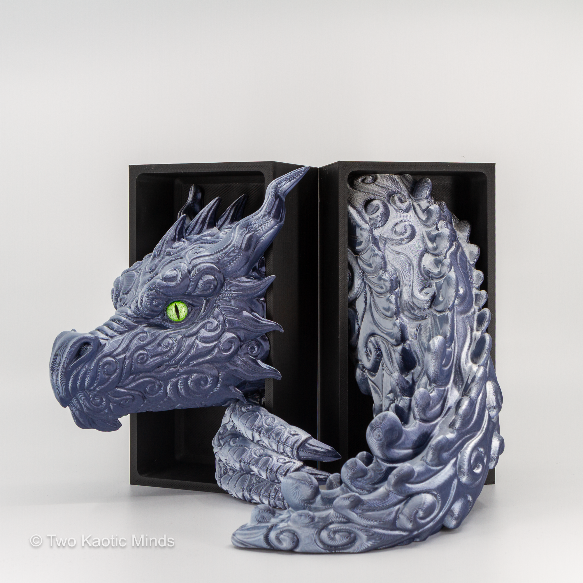 Close front angle of the granite Cloud Dragon showing cloud-like scale texture detail, green eyes, and sweeping dragon neck