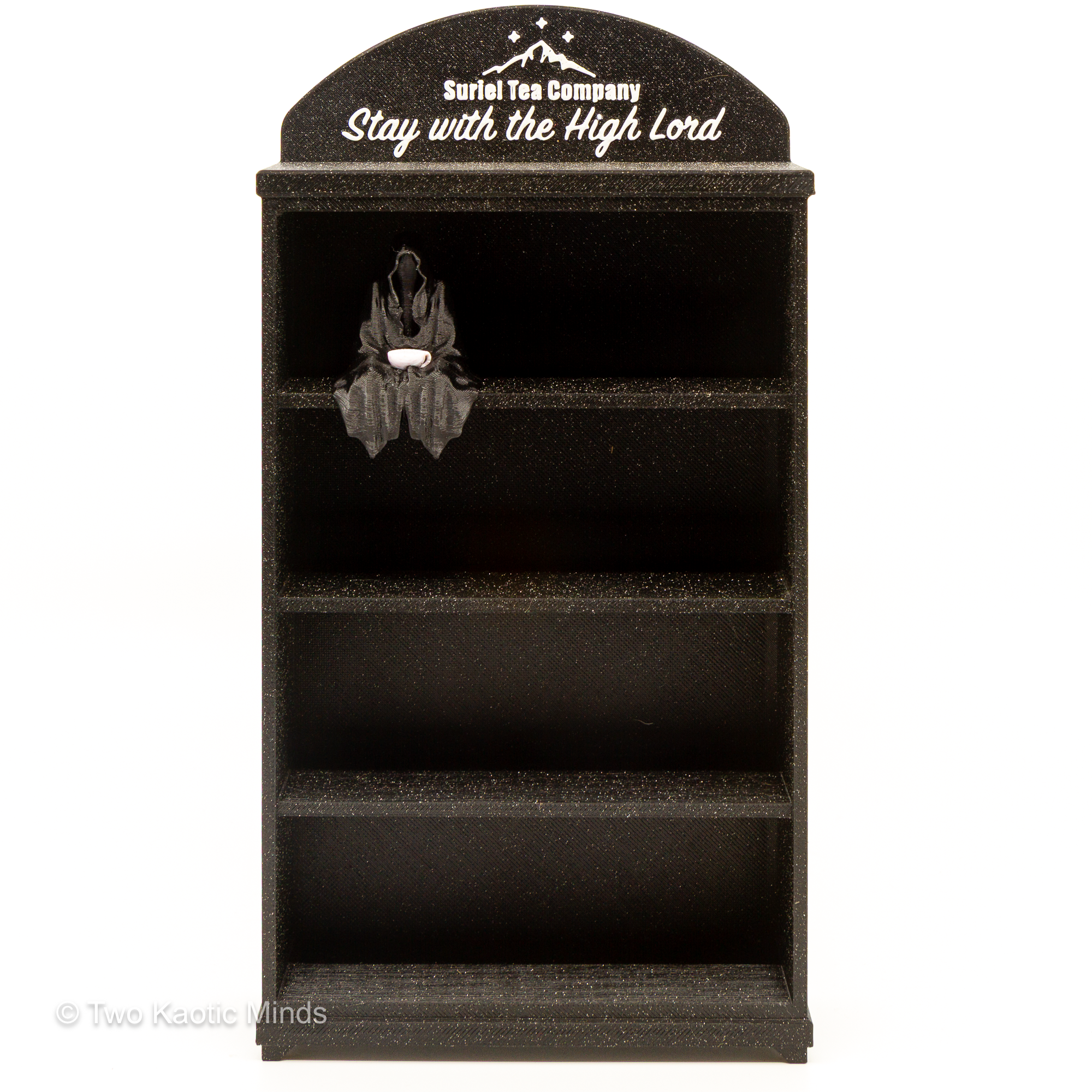 3D printed black glitter ACOTAR mini book shelf with arched header reading Suriel Tea Company Stay with the High Lord, with a small Suriel figurine holding a teacup on the top shelf, front view