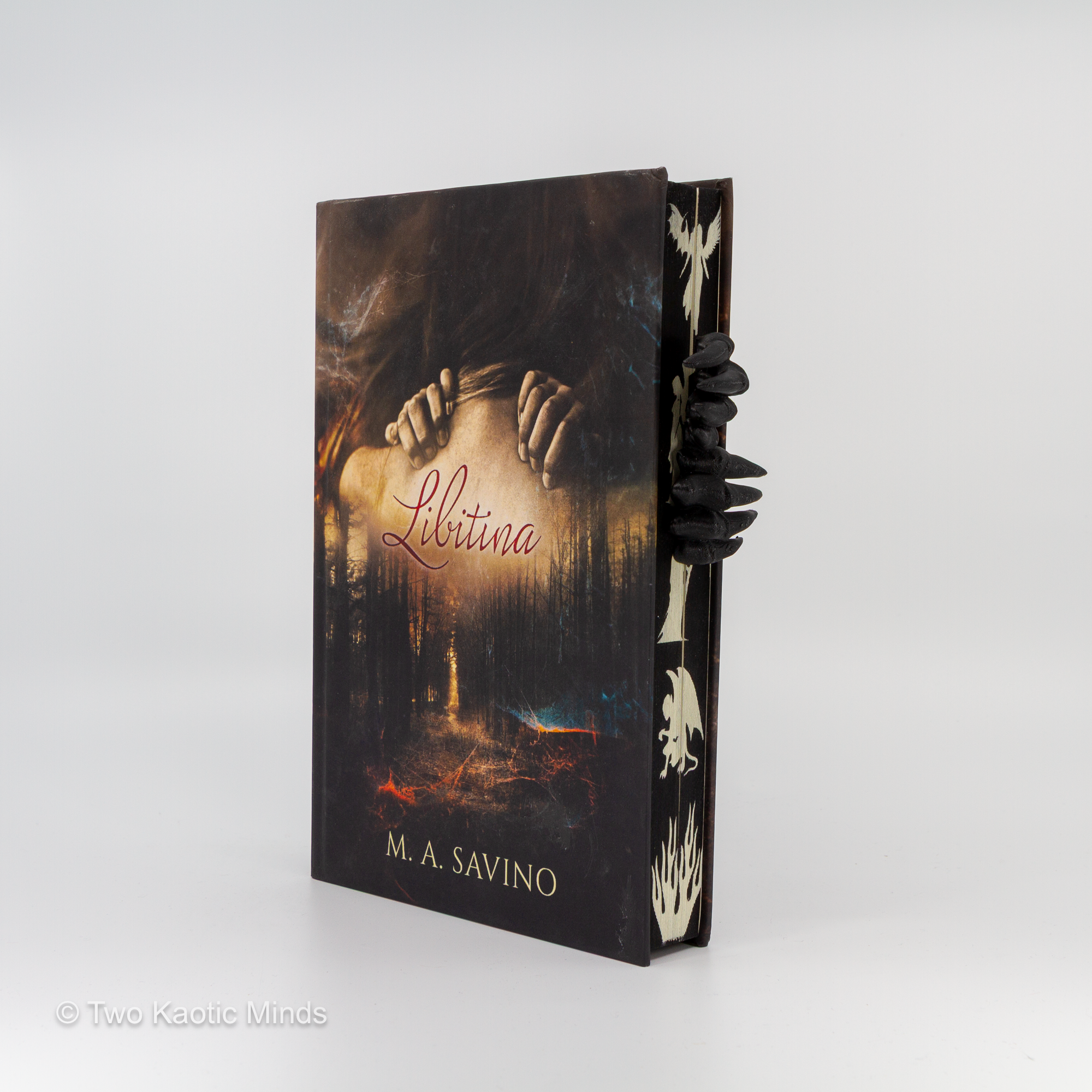Demon Hands bookmark placed over the top of a book, front view showing black skeletal demon claws gripping the pages