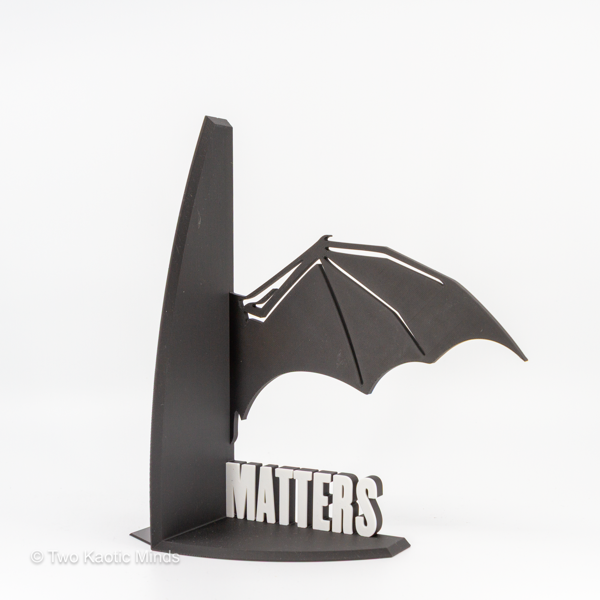 Close-up angled view of the MATTERS dragon wing bookend showing wing detail and white lettering