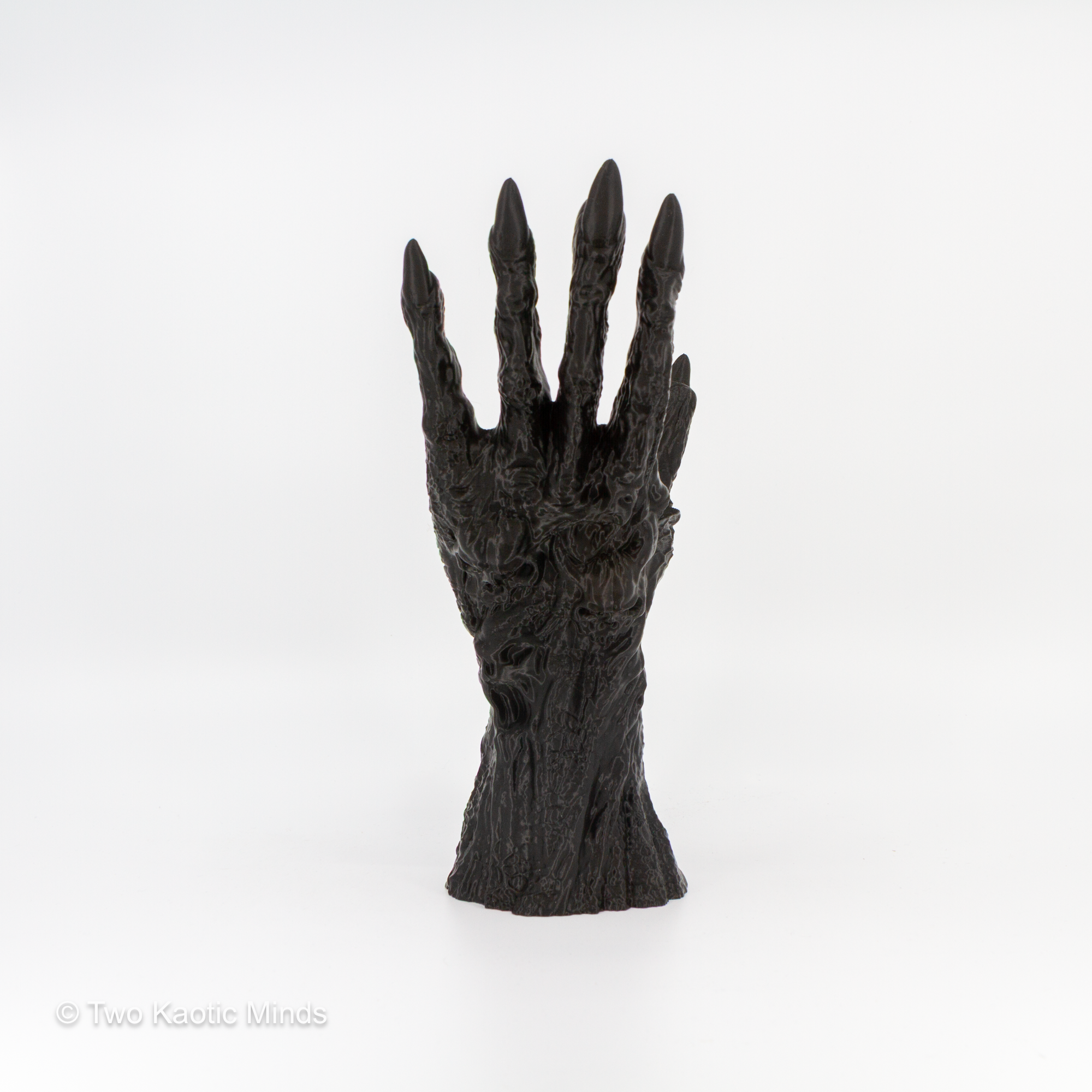 3D printed black clawed hand book holder standing upright on white background, front view showing textured skin and pointed fingertips