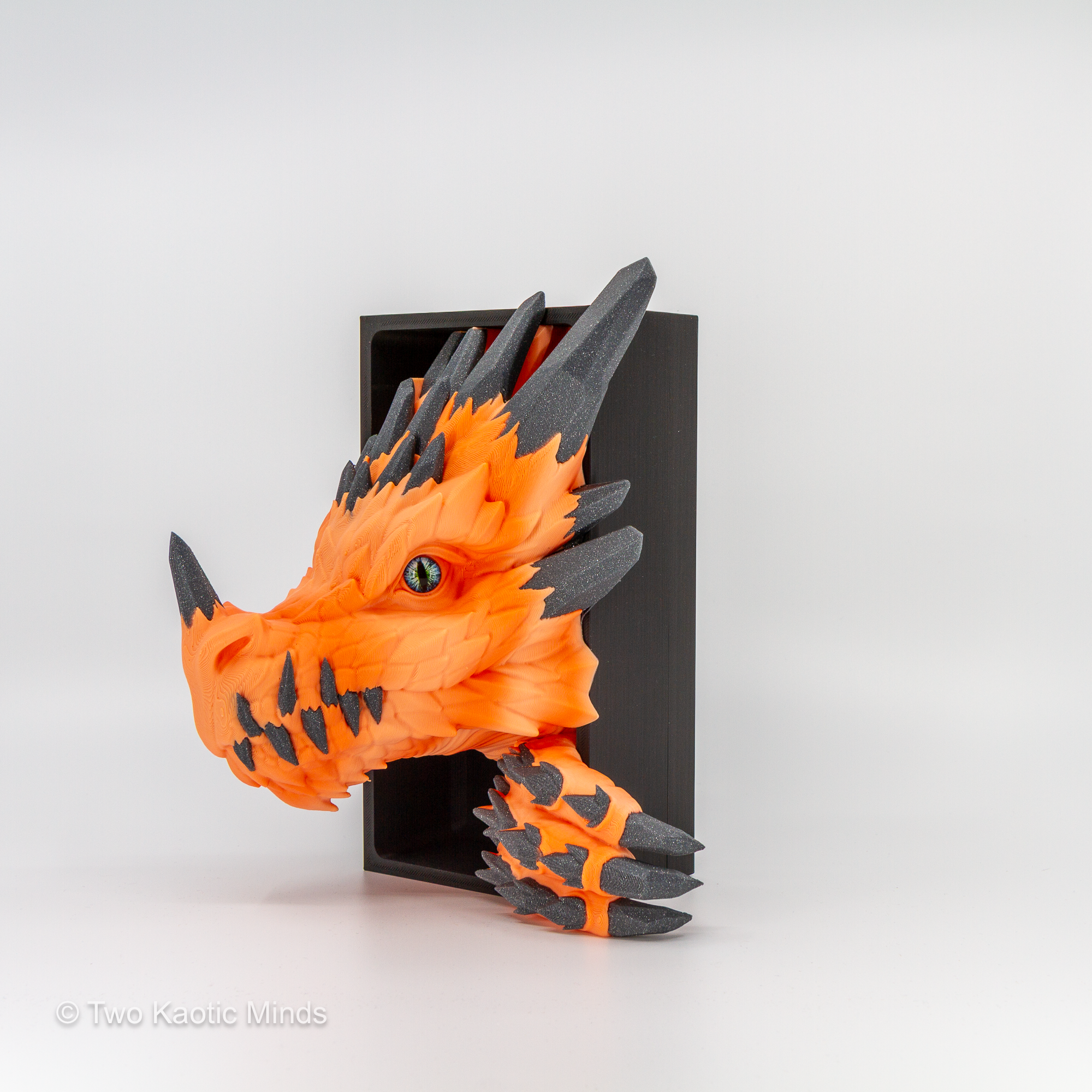 3D printed Crystal Dragon book nook in sunrise orange and grey sparkle two-tone PLA, dragon head emerging from a matte black box, front angle view