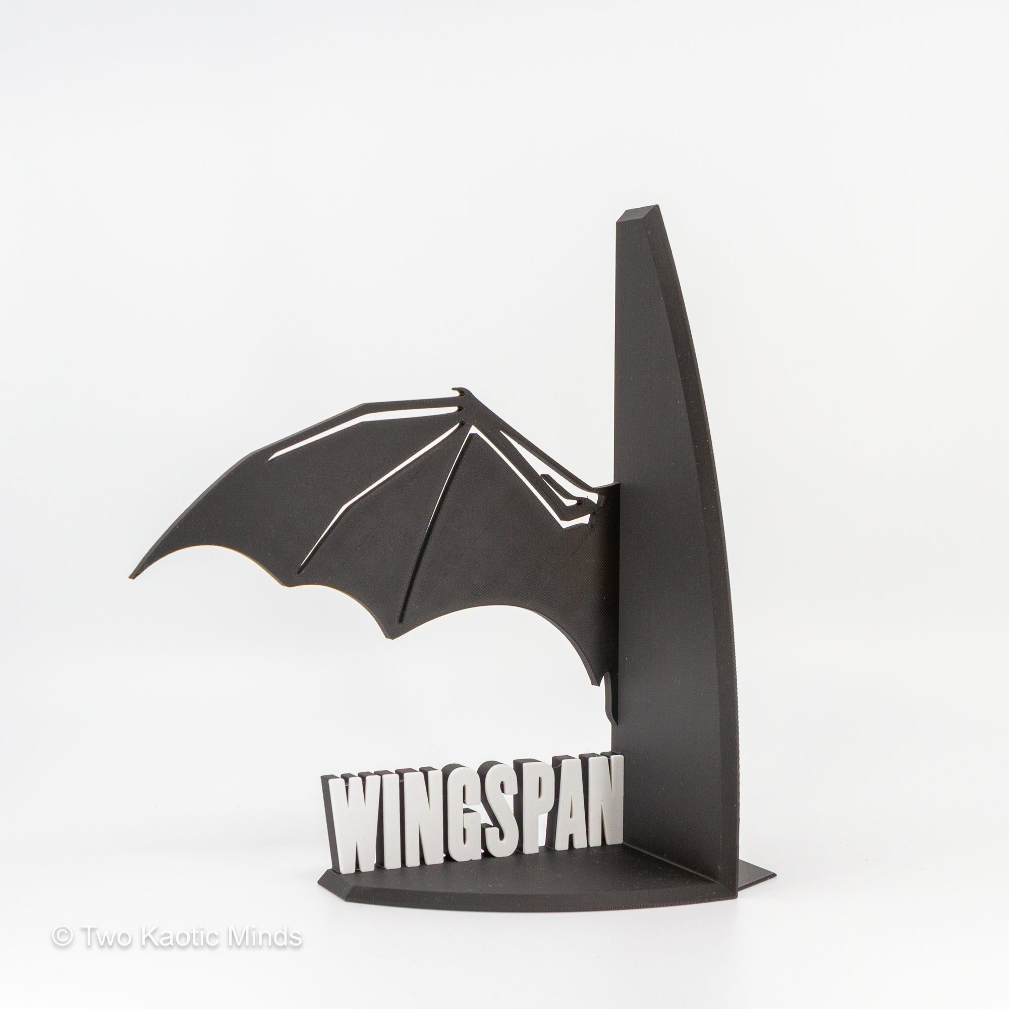 Close-up angled view of the WINGSPAN dragon wing bookend showing wing detail and white lettering