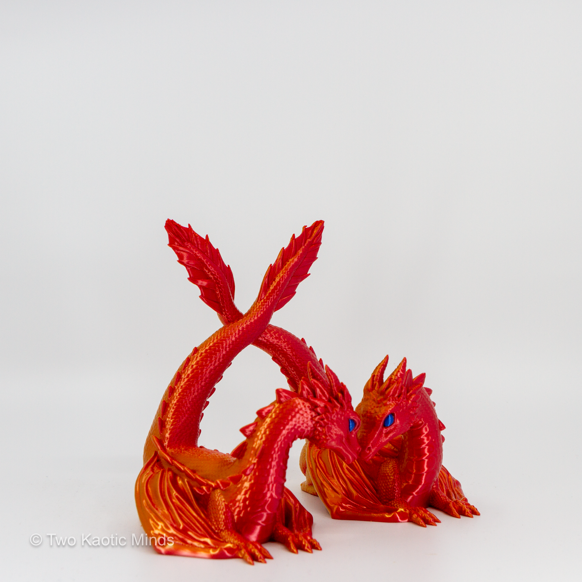 3D printed Sunset red and orange twin dragon book holder with two dragons facing each other, front view on grey background