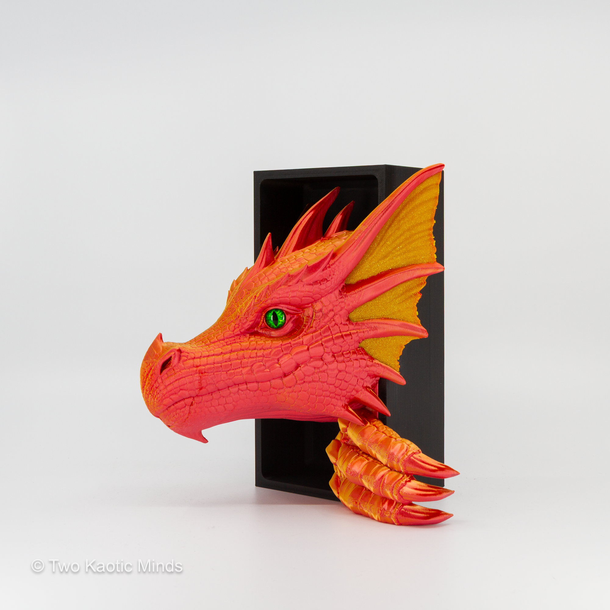 Angled front view of the Sunset-Gold Sea Dragon showing warm red-orange body and opaque gold fin detail with green glass eye