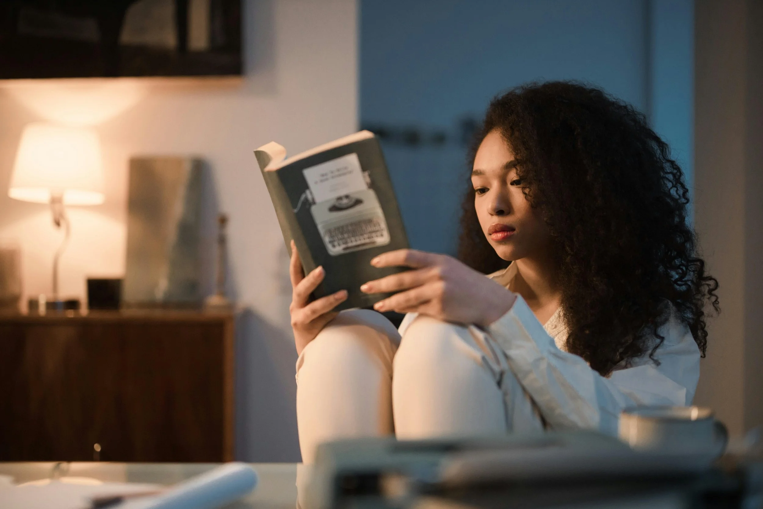A calm woman sitting reading a book, representing the groundedness and steadiness that emotional regulation therapy in Florida helps clients develop