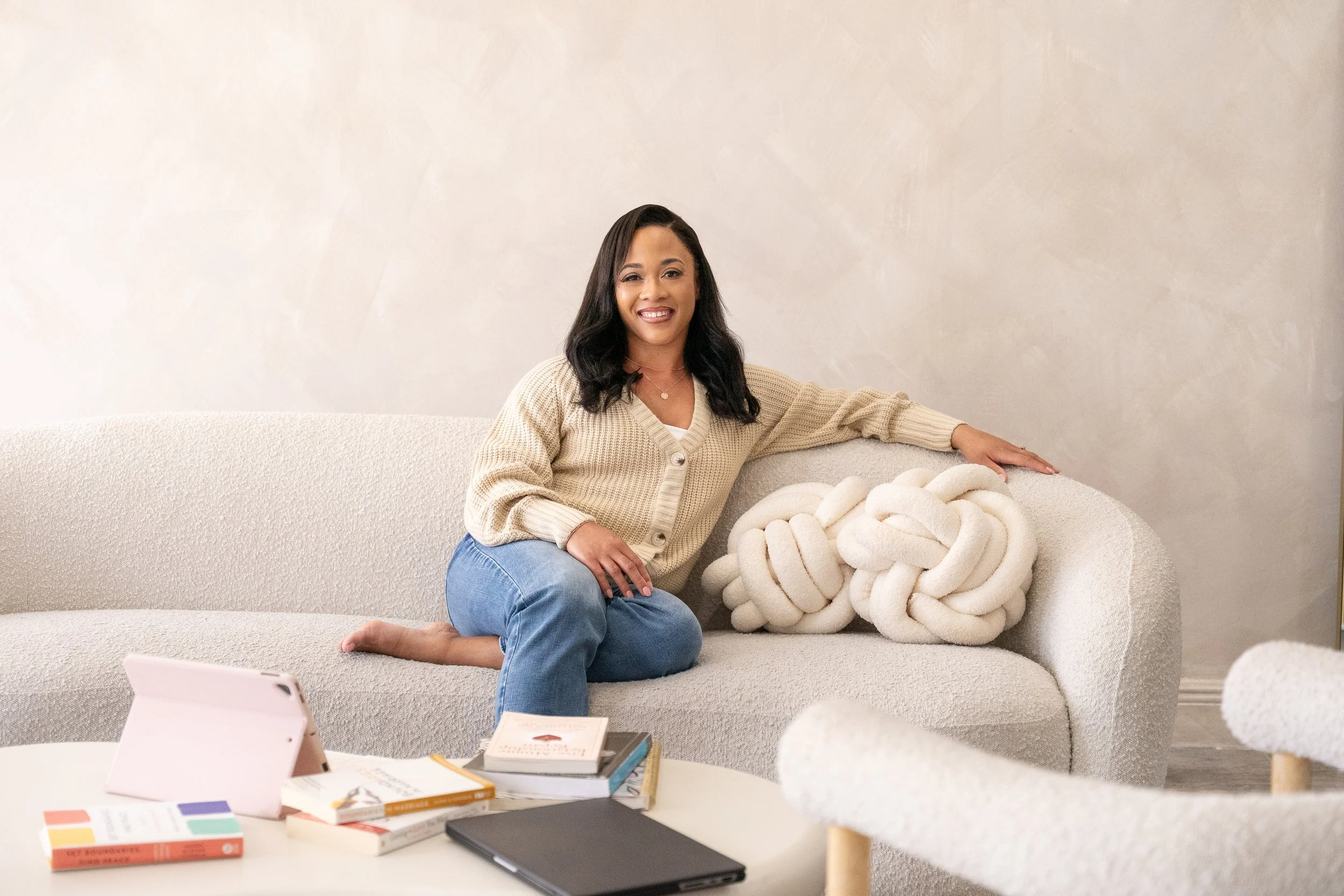 Kristin Crumbley, LMHC, LMFT, sitting on a couch in a calm, welcoming therapy space, offering online individual and couples therapy across Florida.