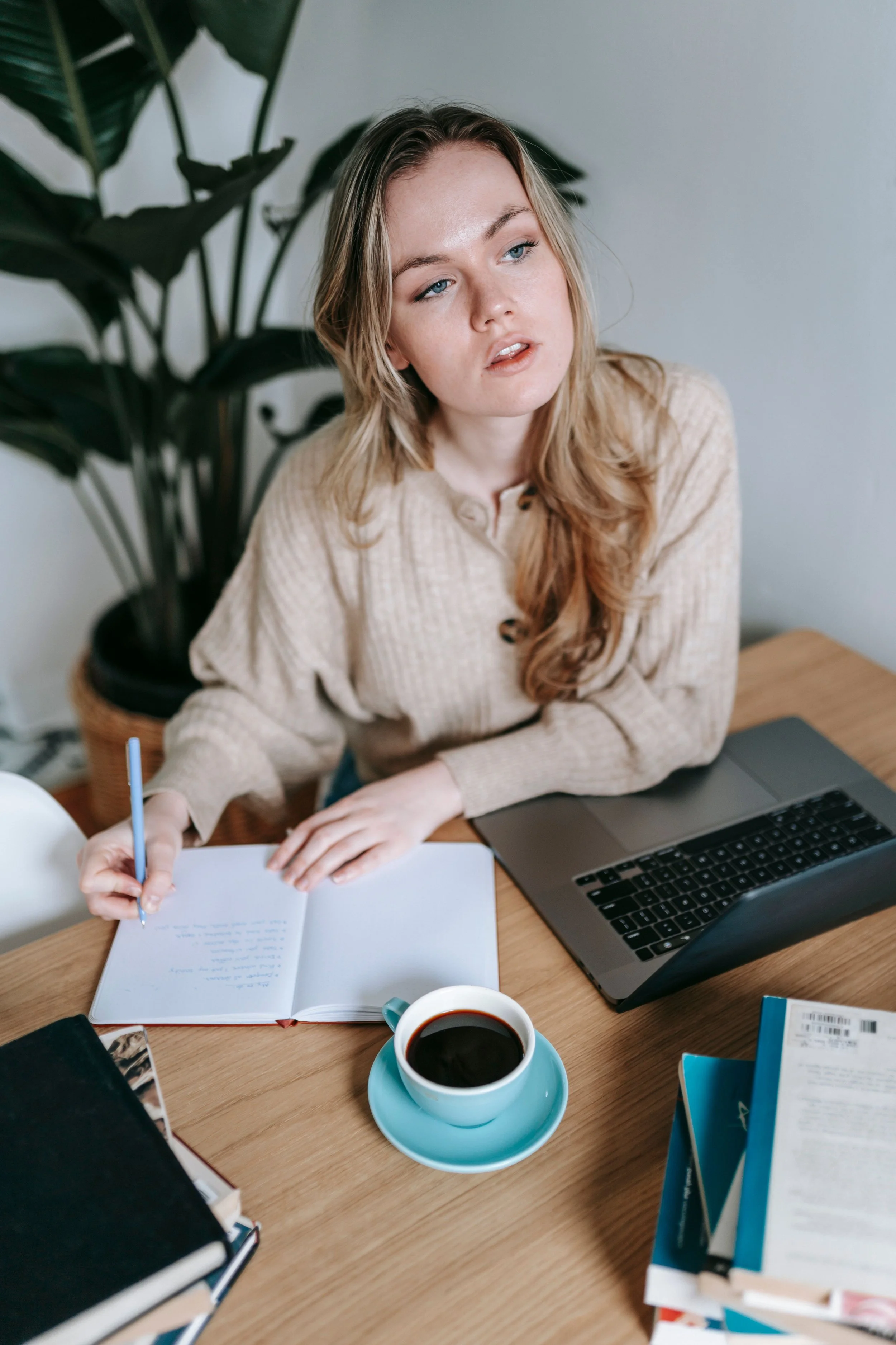 A woman quietly managing responsibilities at a kitchen table, representing the mental load dynamic addressed in couples therapy in Florida