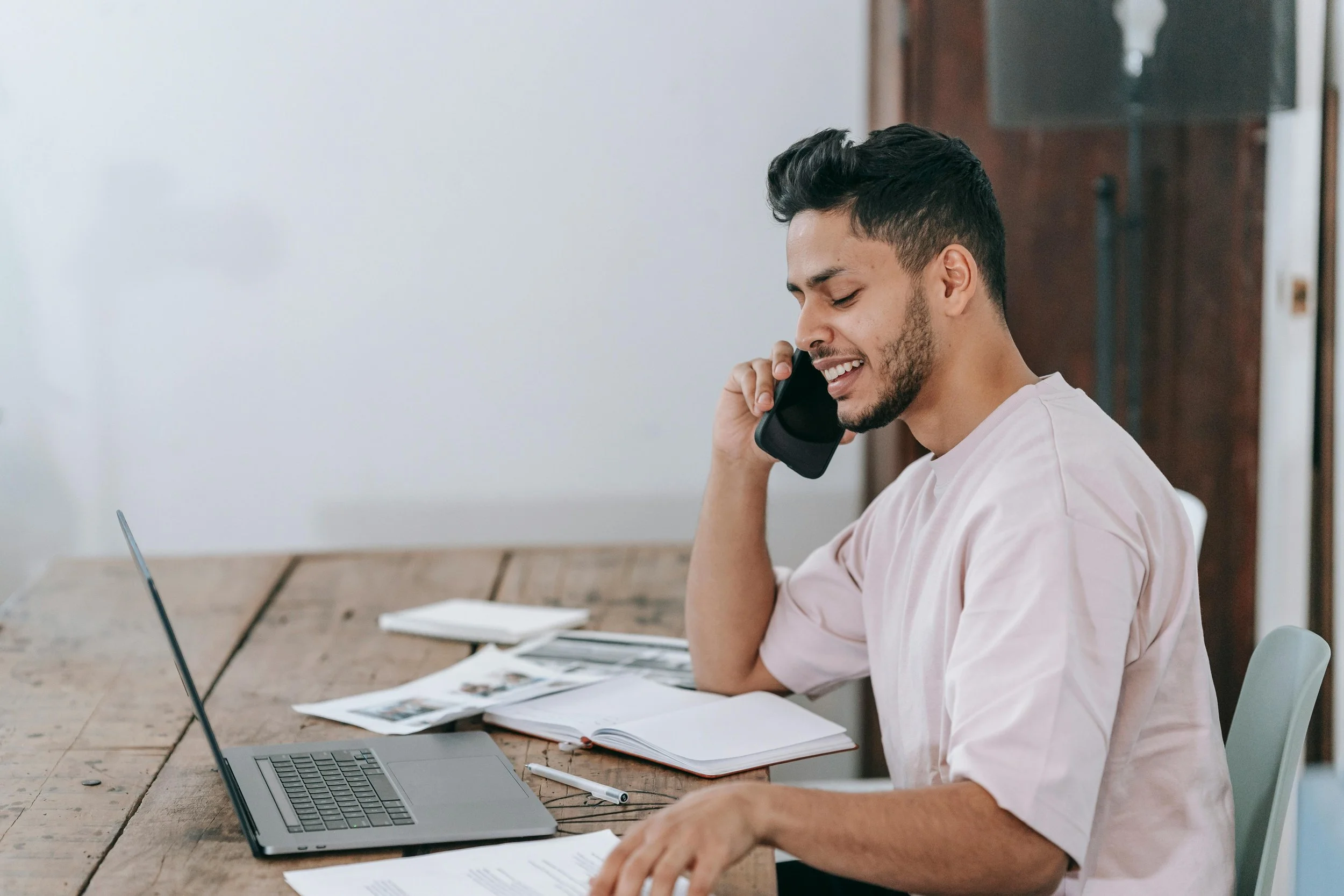 A professional on a phone call at a desk with a laptop, representing the clinical consultation services available to licensed therapists in Florida