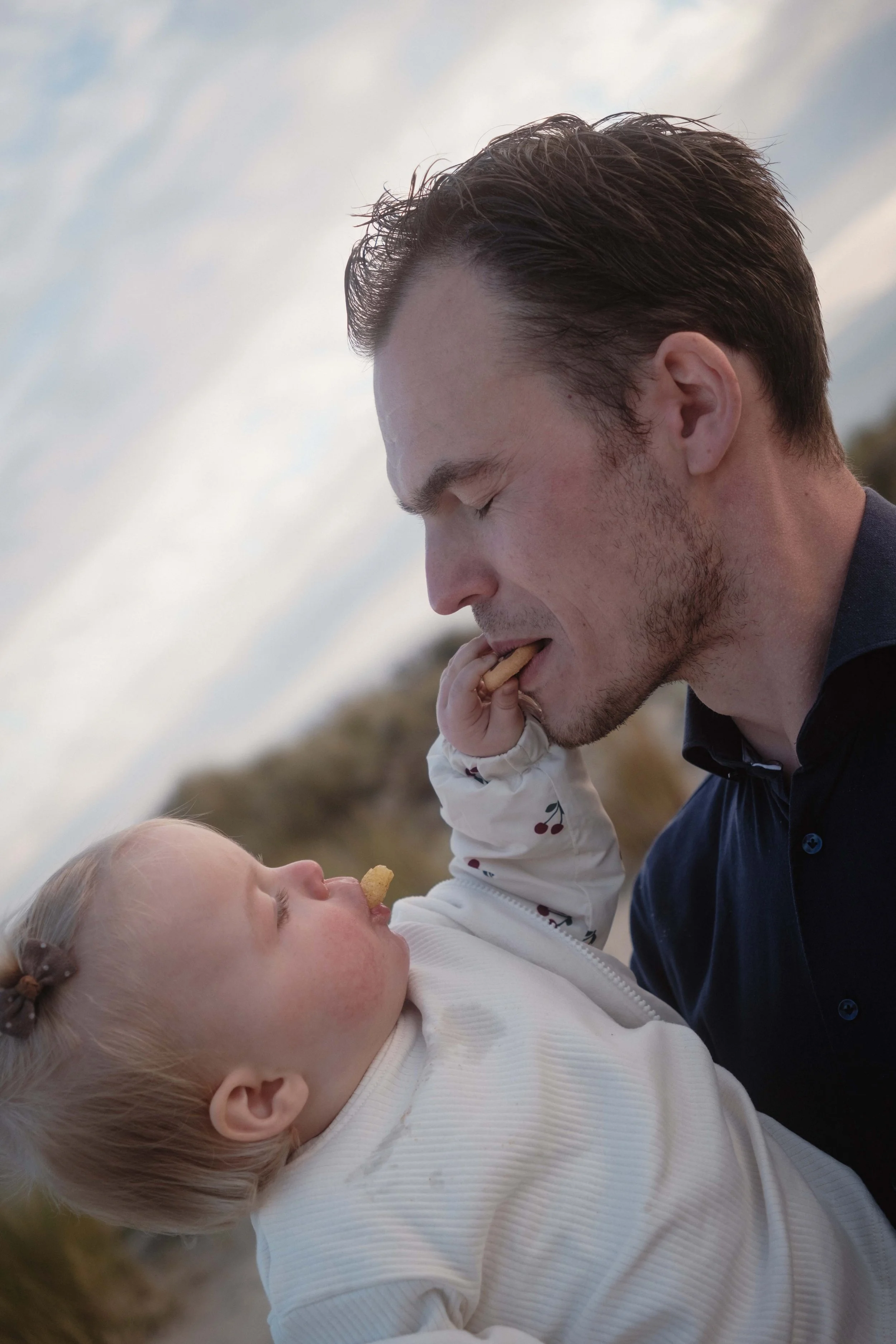father eating a cookie with his daughter