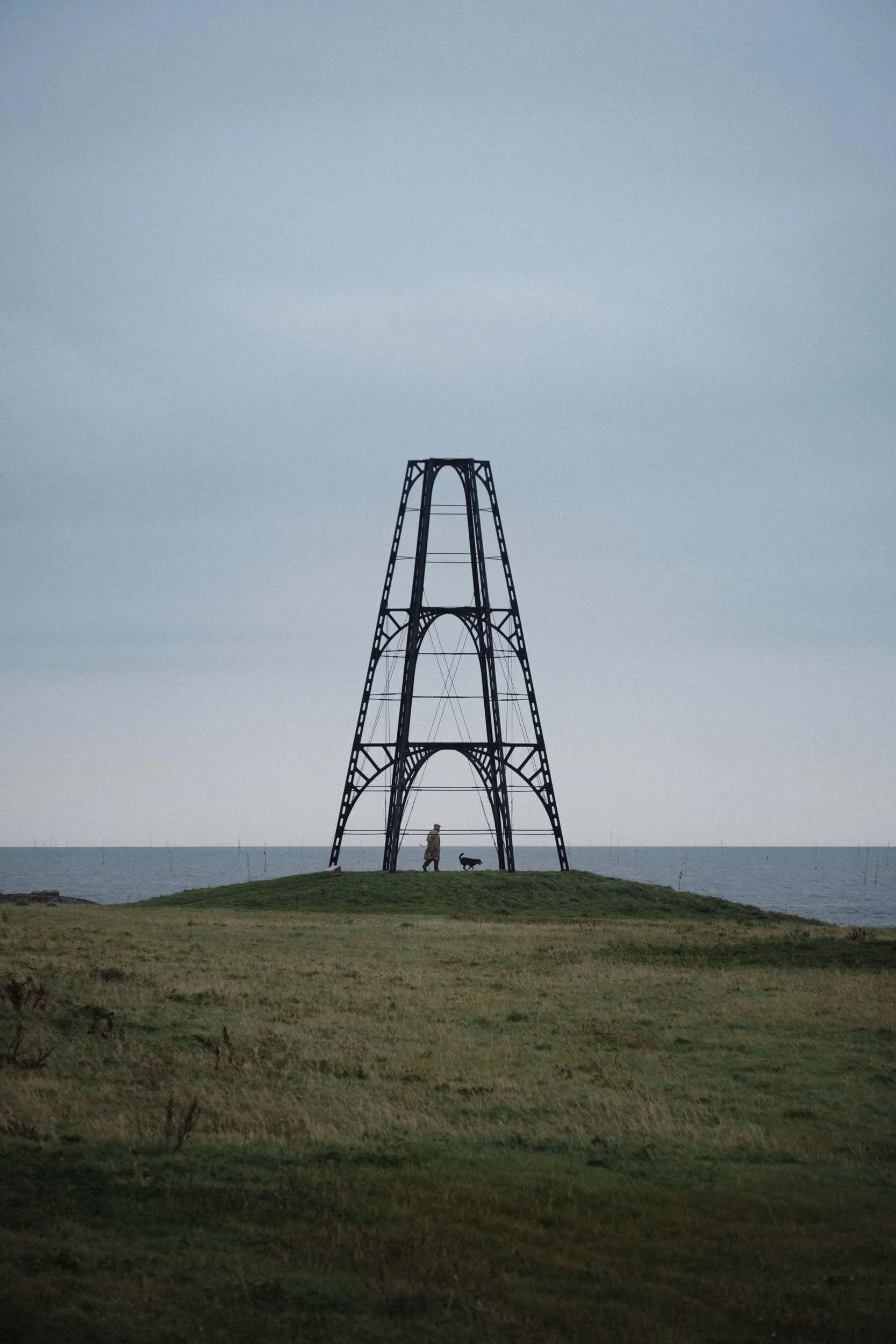 man and dog walk through ijzeren kaap on texel